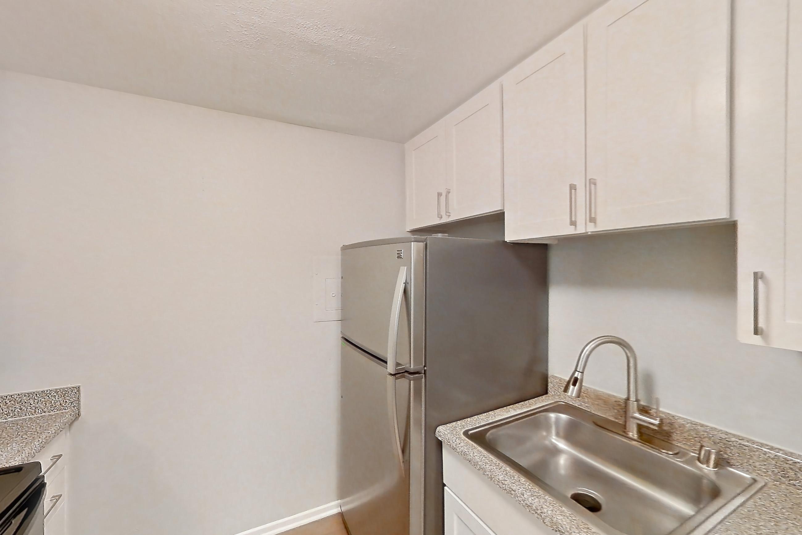 Kitchen with dishwasher, light countertops, light wood-finish flooring, refrigerator, and stainless steel appliances, Apartment 13-08 at Avana Rancho Cucamonga