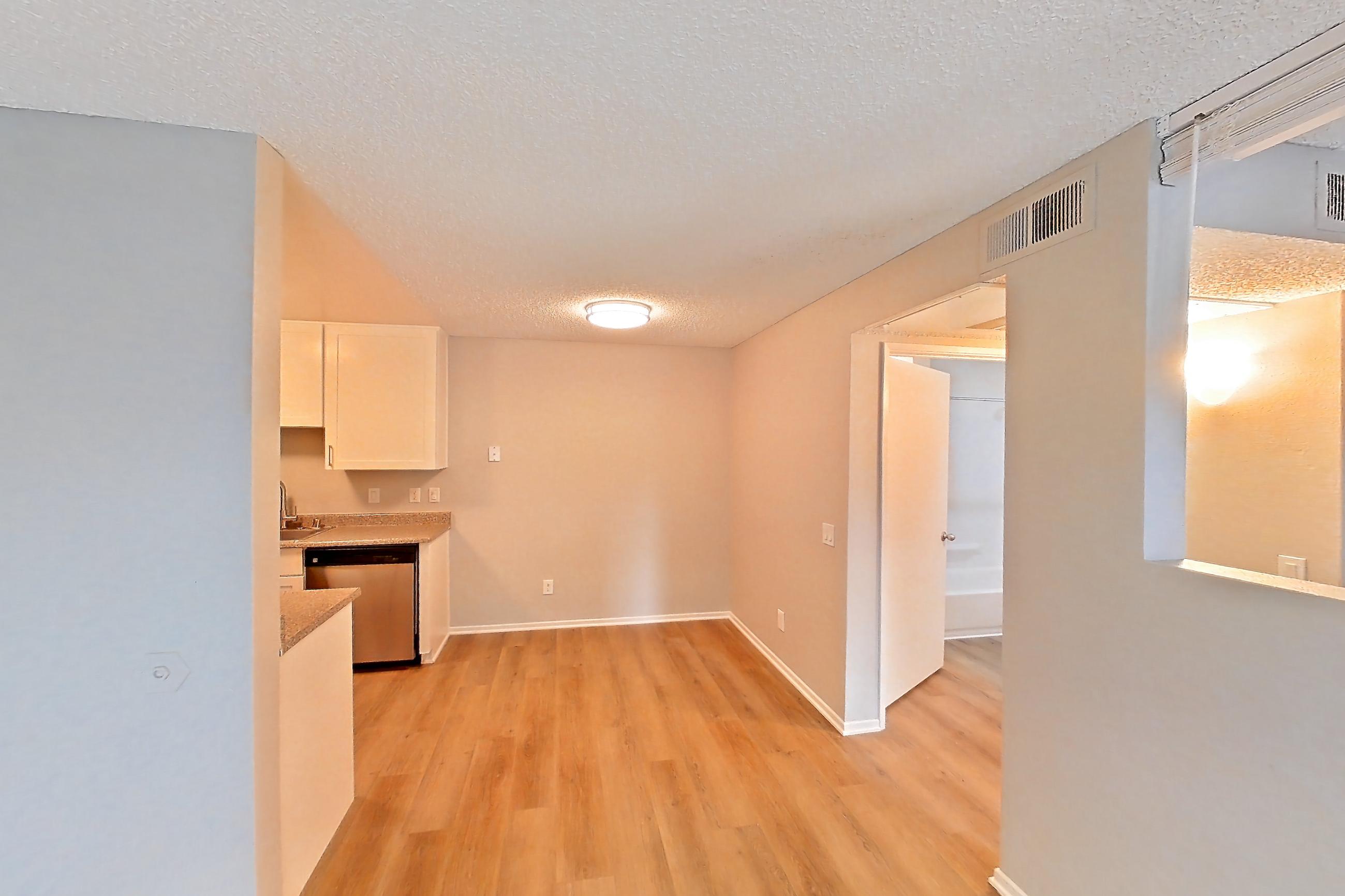 Living room with dishwasher, light wood-finish flooring, and stainless steel appliances, Apartment 13-08 at Avana Rancho Cucamonga