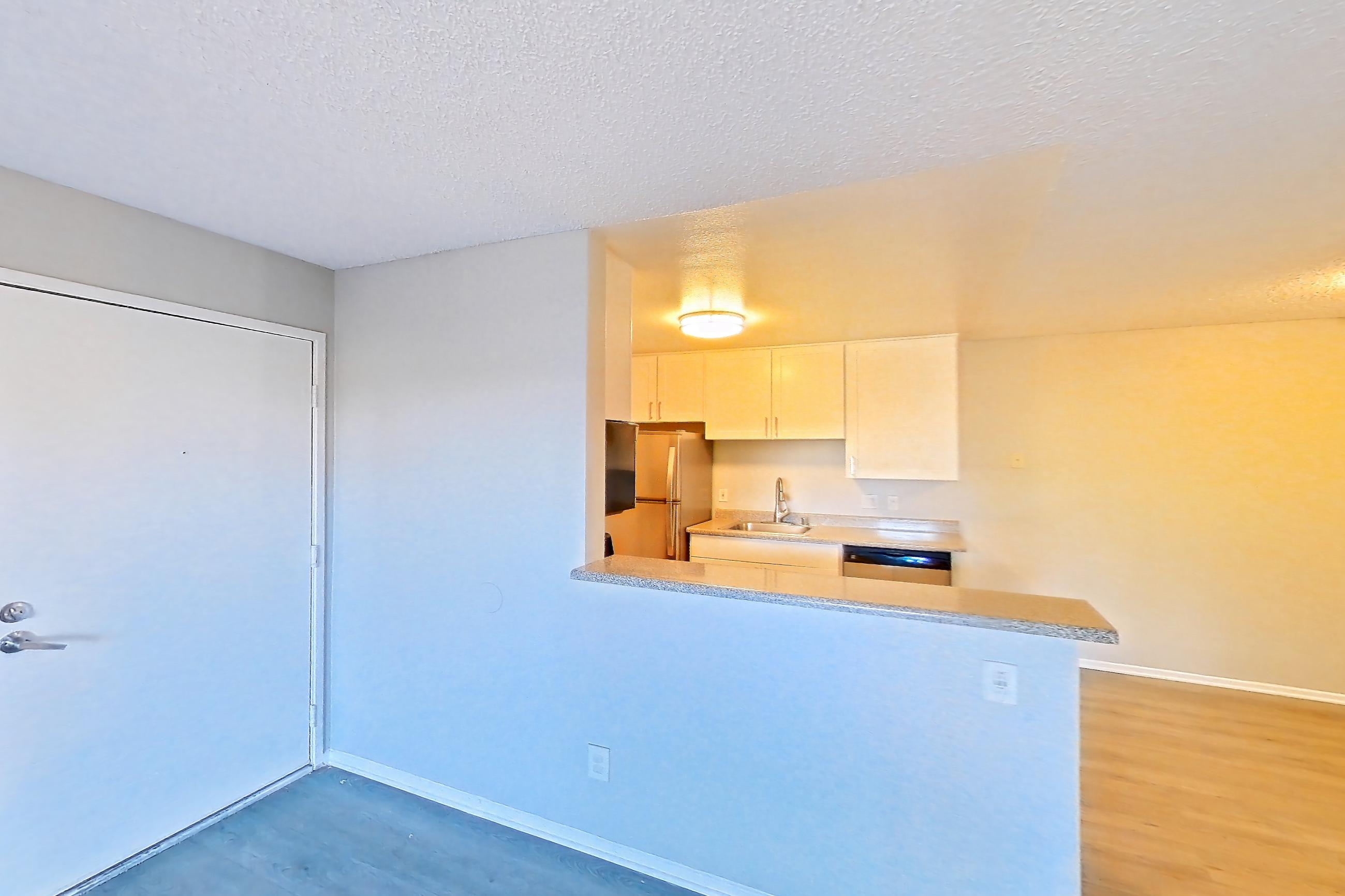 Living room with dishwasher and stainless steel appliances, Apartment 19-10 at Avana Rancho Cucamonga