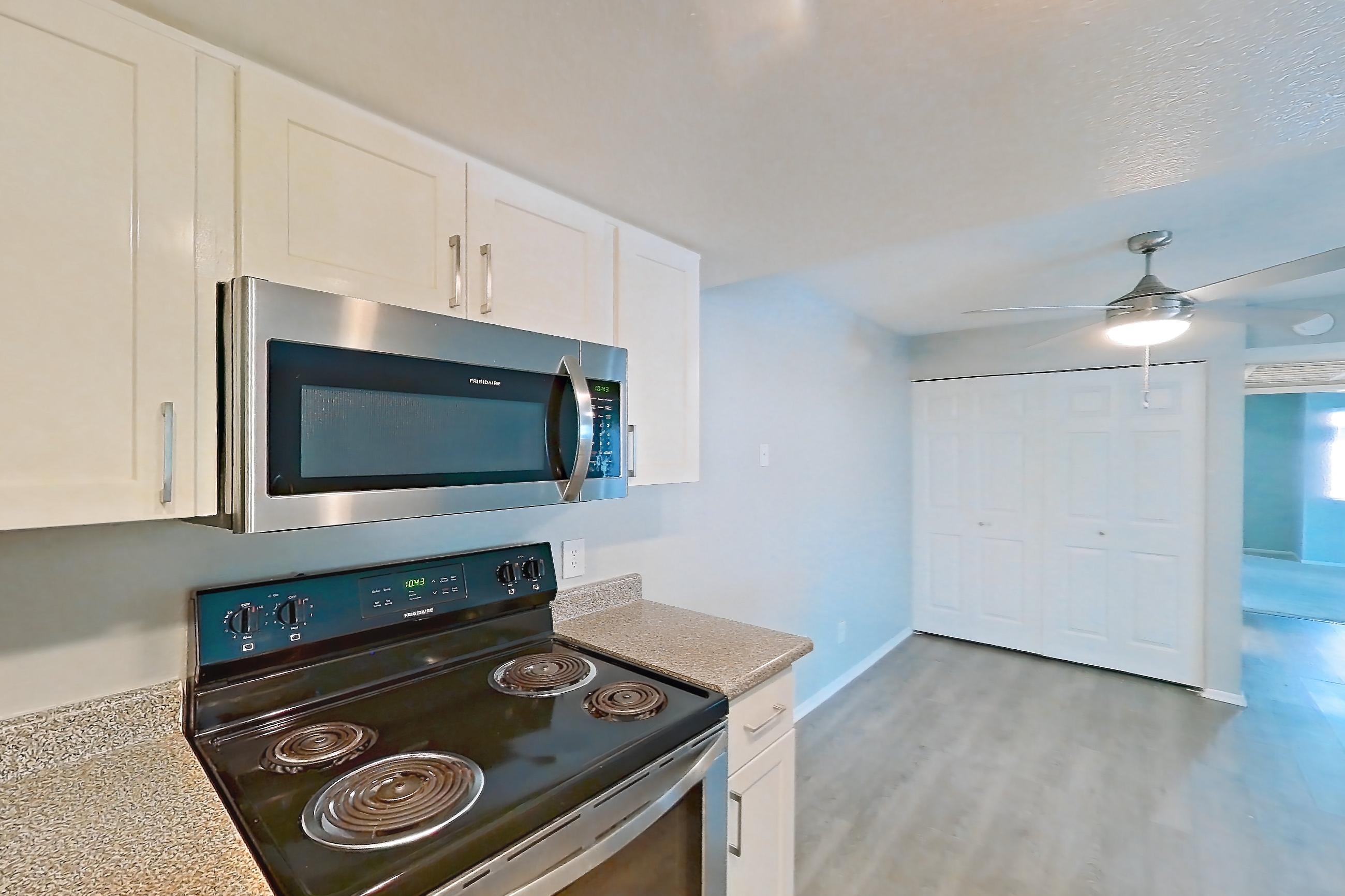 Kitchen with dishwasher, electric range, light countertops, oven/range, and stainless steel appliances, Apartment 06 at Avana Rancho Cucamonga