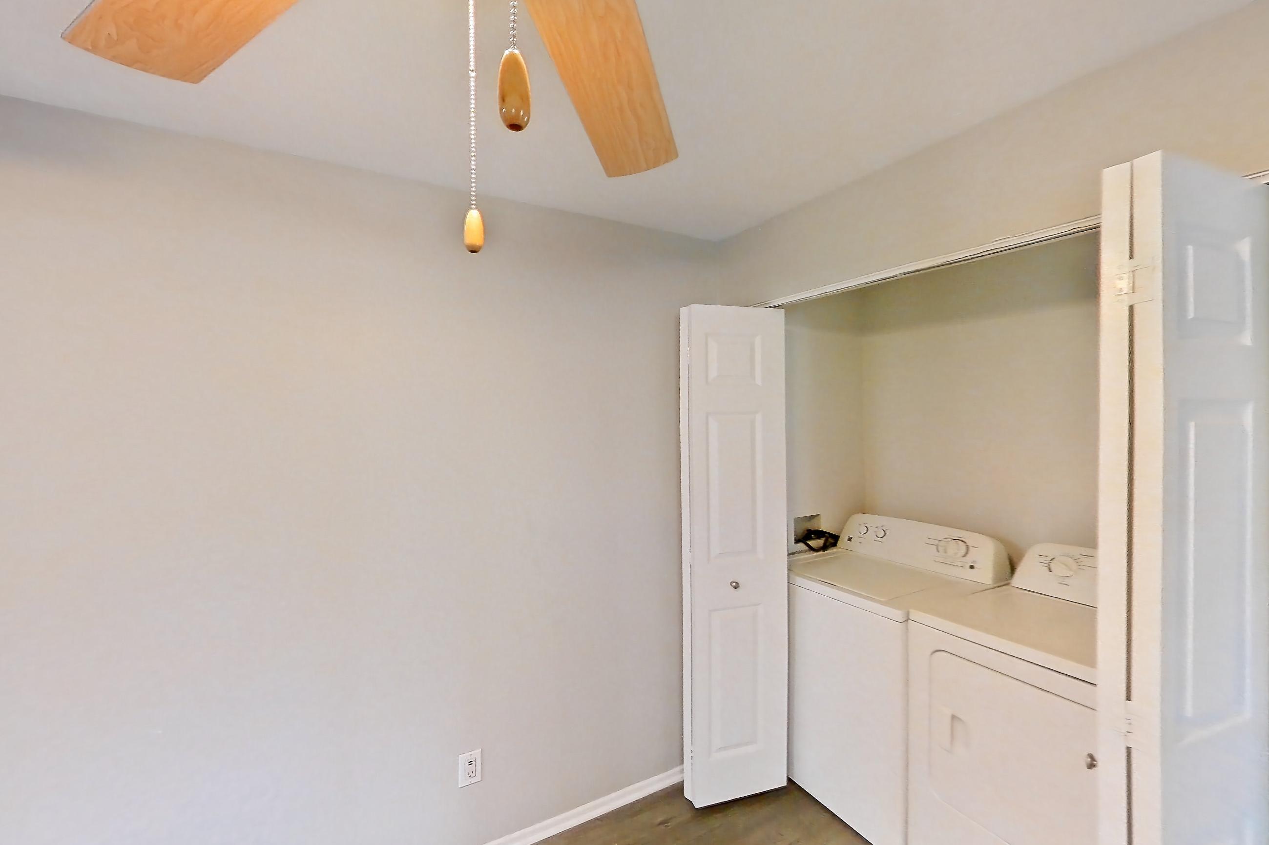 Dining room with dark wood-finish flooring, in-unit laundry, light countertops, and light wood-finish flooring, Apartment 23 at Avana Rancho Cucamonga