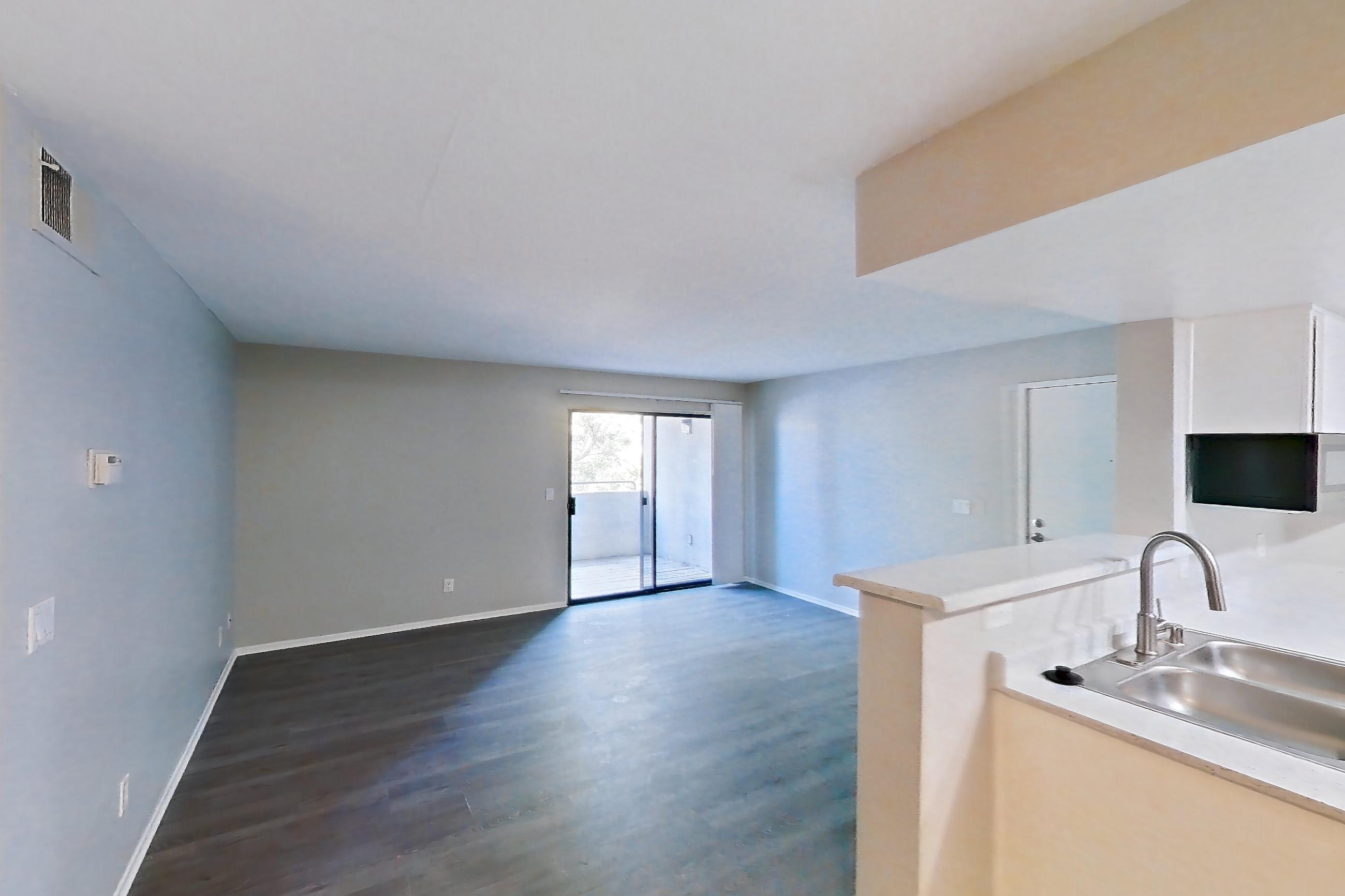 Dining room with dark wood-finish flooring, in-unit laundry, light countertops, and light wood-finish flooring, Apartment 23 at Avana Rancho Cucamonga