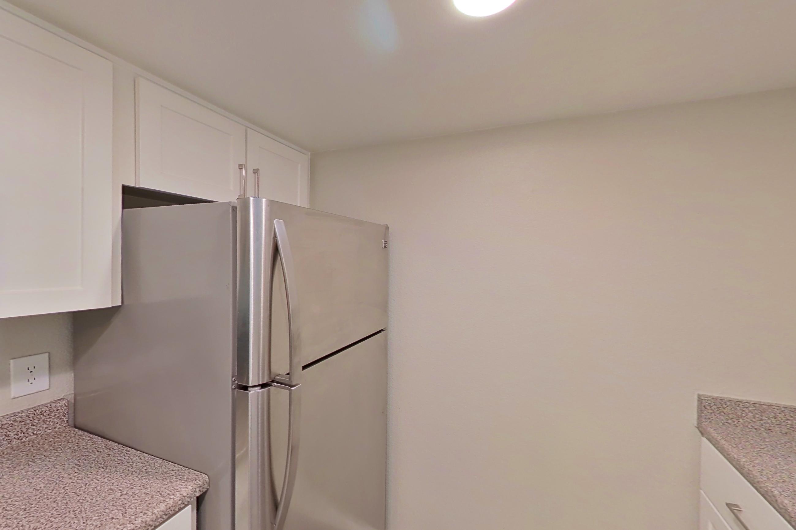 Kitchen with dishwasher, electric range, light countertops, light stone countertops, light wood-finish flooring, oven/range, refrigerator, and stainless steel appliances, Apartment 24 at Avana Rancho Cucamonga