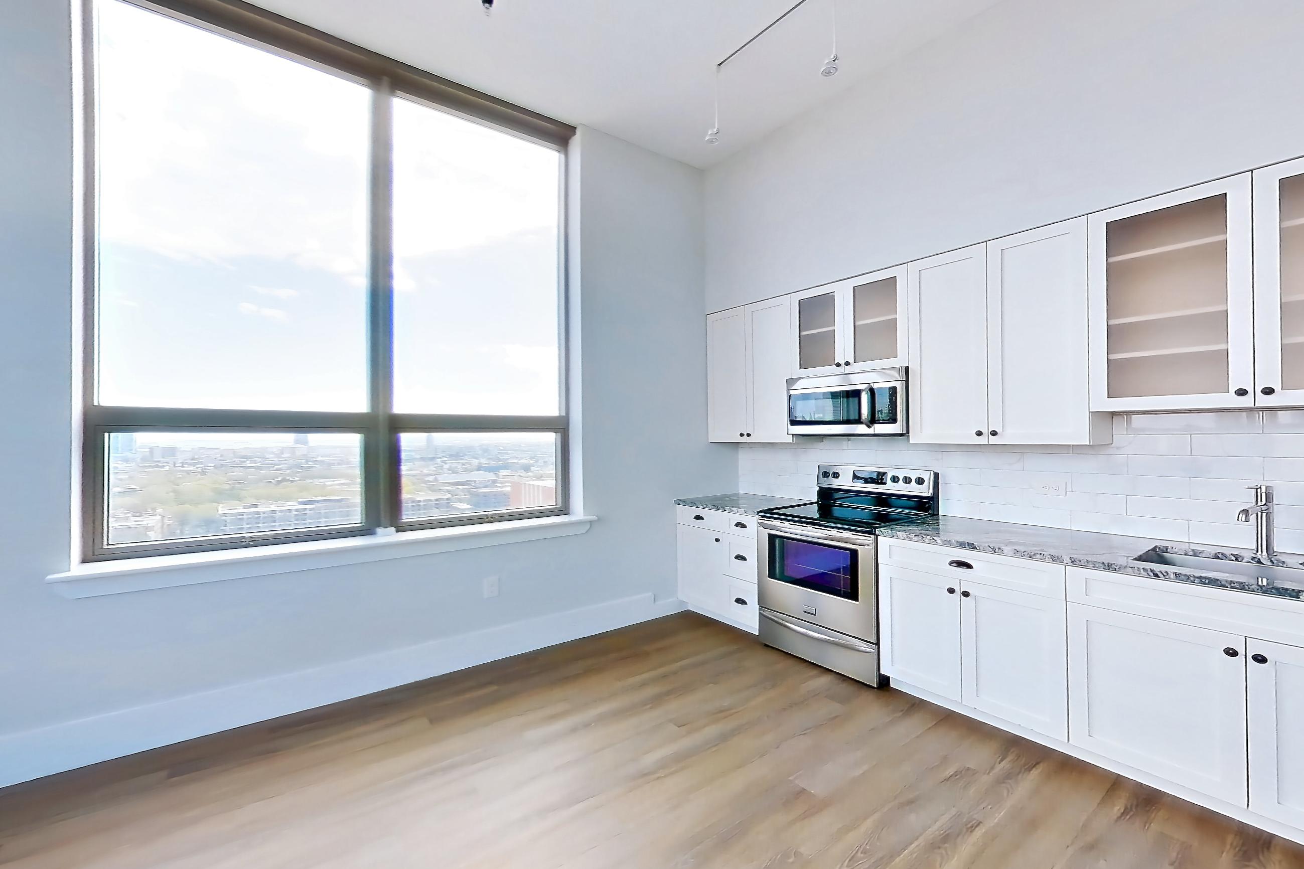 Living space with light wood-finish flooring, oven/range, and stainless steel appliances, Apartment SL-PH07 at Soho Lofts