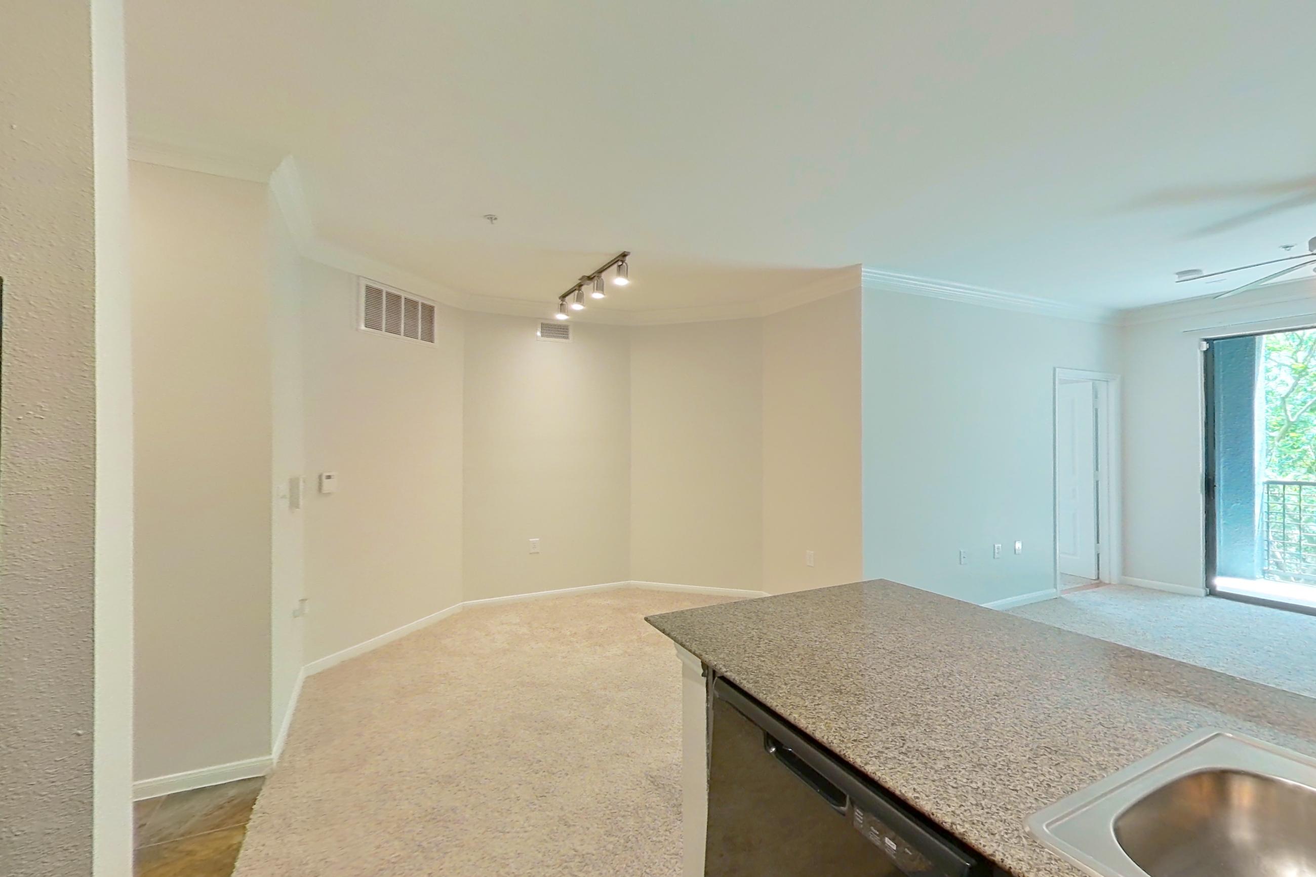 Kitchen with black appliances, dark stone-finish flooring, dishwasher, electric range, light stone countertops, microwave, oven/range, refrigerator, and stainless steel appliances, Apartment 0234 at Portico Kirby