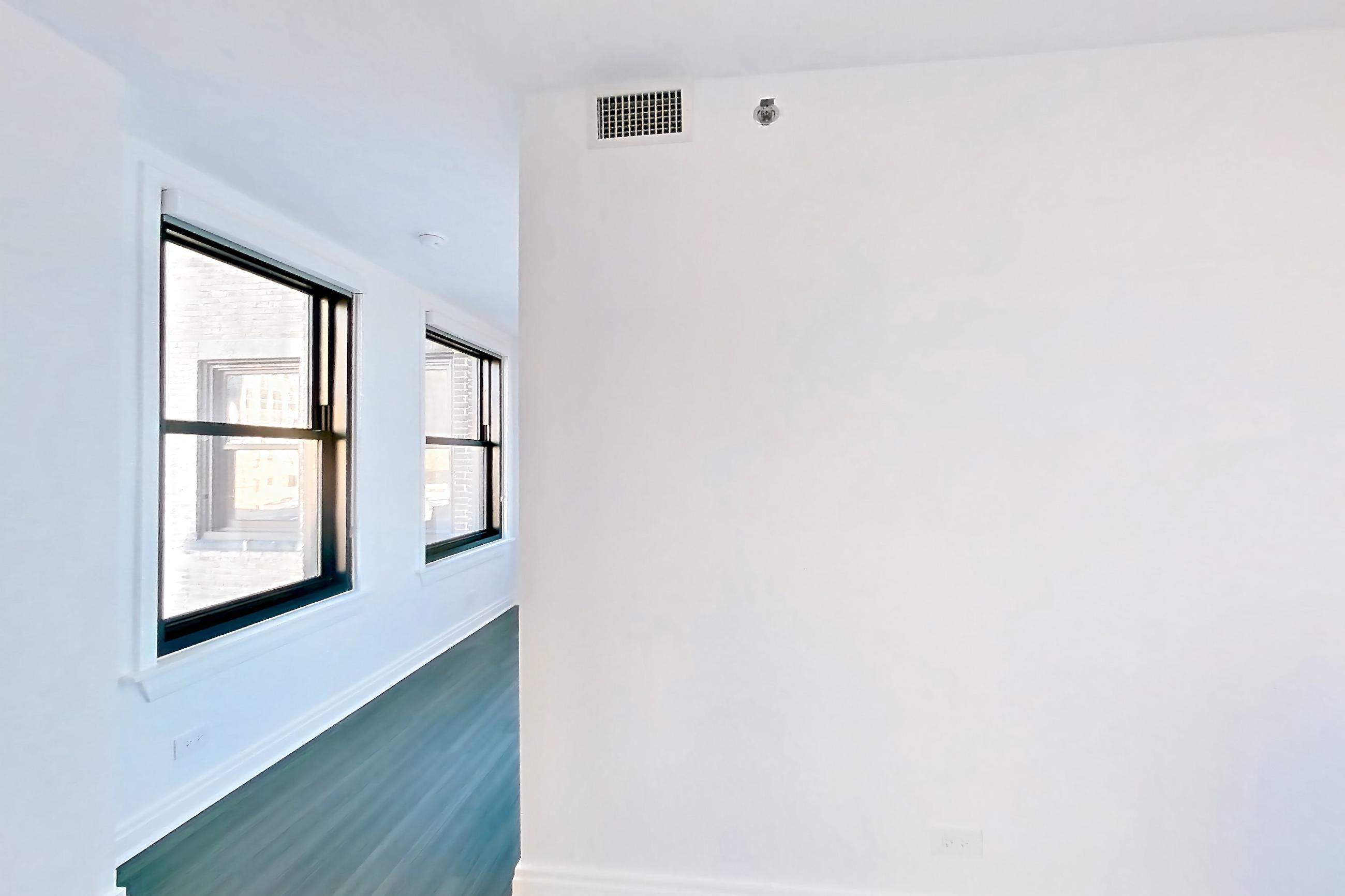 Living room with dark wood-finish flooring, Apartment 510 at The Belden-Stratford
