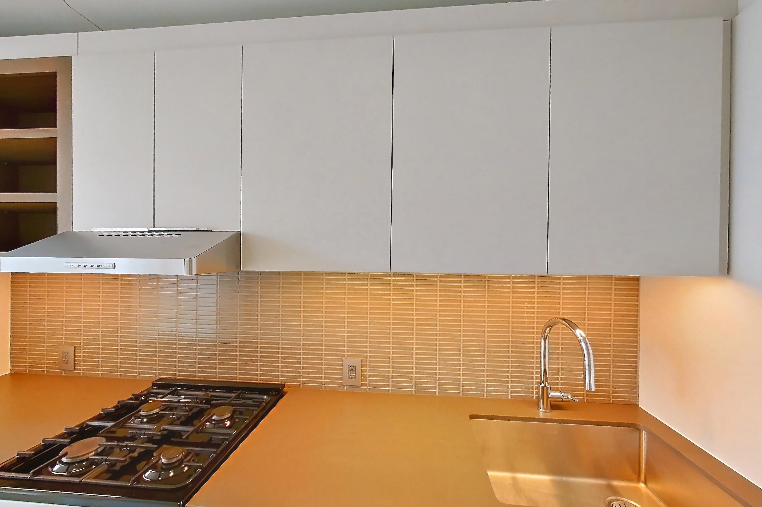 Kitchen with gas range, light wood-finish flooring, oven/range, stainless steel appliances, and wood-finish flooring, Apartment 0-PHH at One Blue Slip