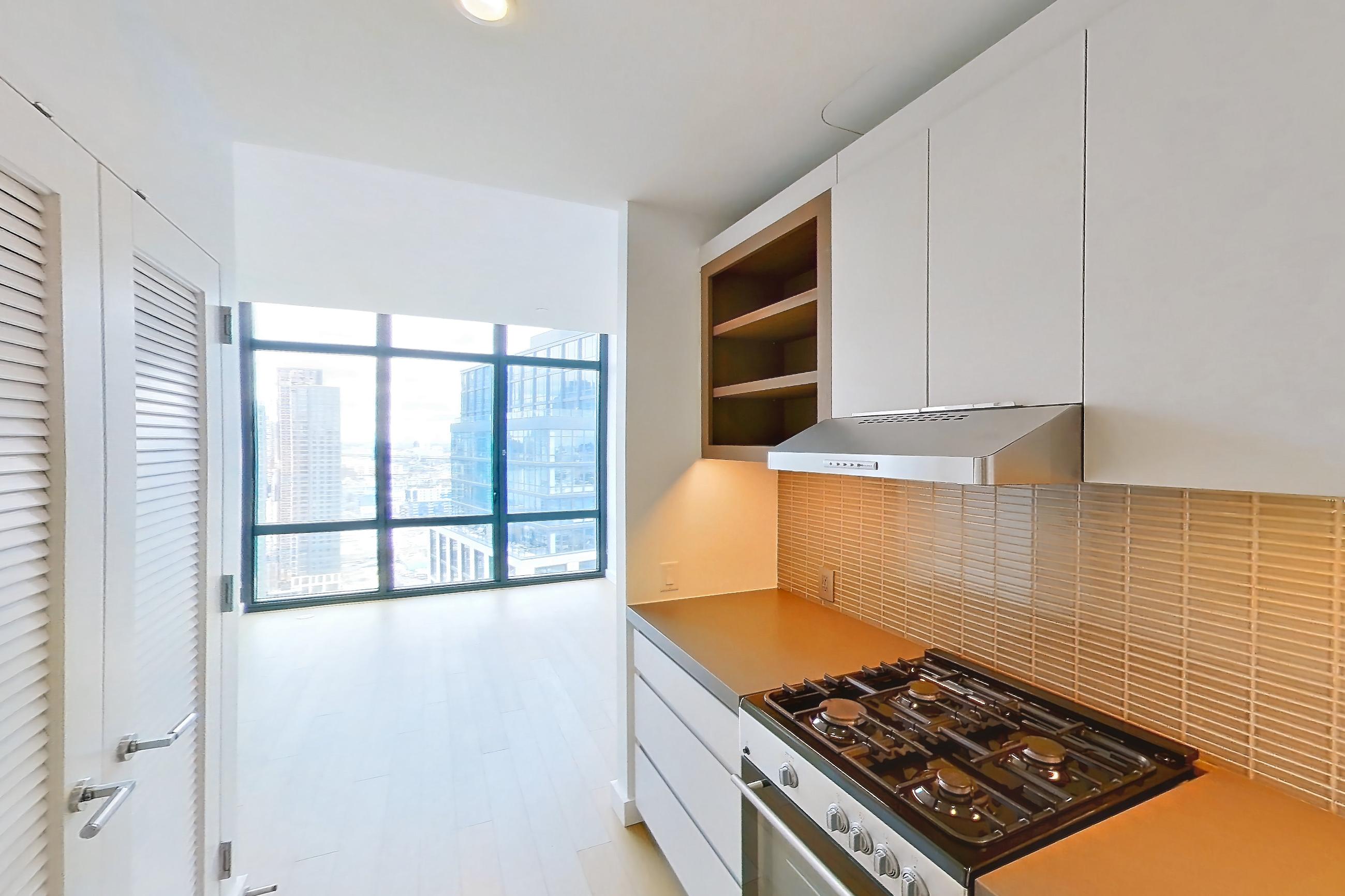 Kitchen with gas range, light wood-finish flooring, oven/range, stainless steel appliances, and wood-finish flooring, Apartment 0-PHH at One Blue Slip