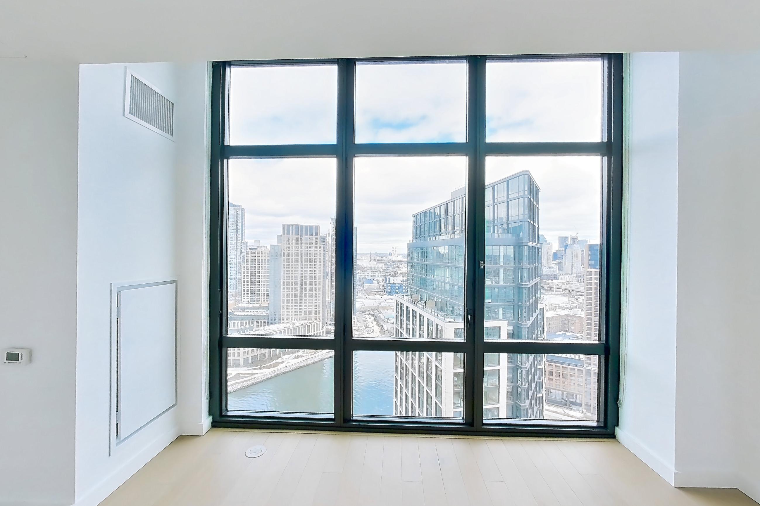 Living room with city view, light wood-finish flooring, and water view, Apartment 0-PHH at One Blue Slip