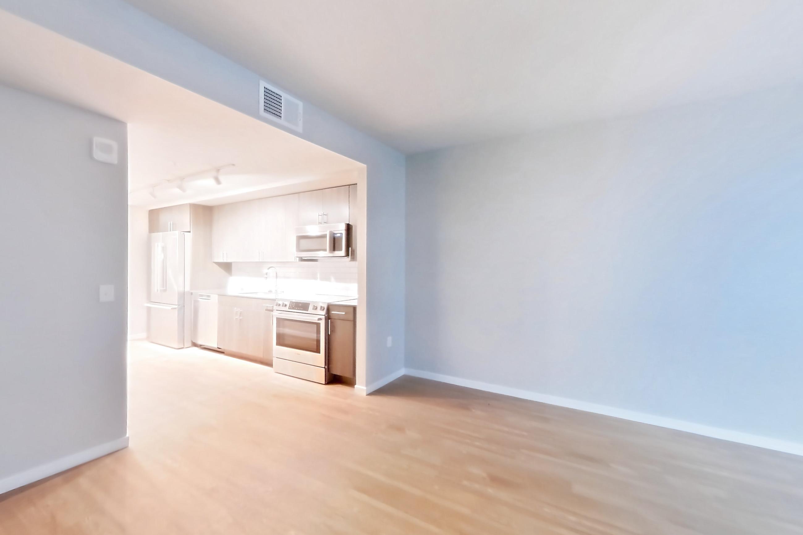 Living room with light wood-finish flooring, oven/range, and white appliances, Apartment 1-1302 at Cortland Rosslyn