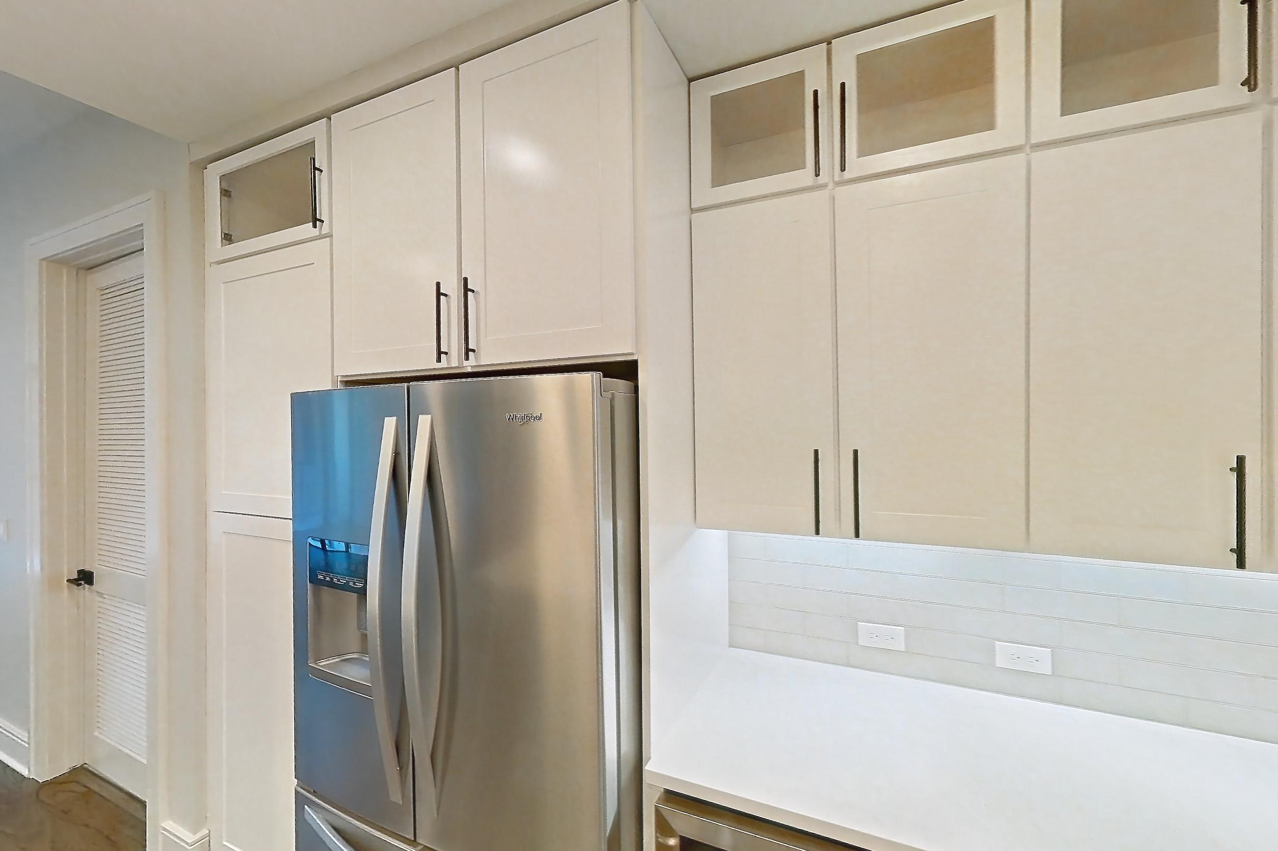 Kitchen with cooktop, dark wood-finish flooring, dishwasher, double oven, gas cooktop, gas range, light countertops, light stone countertops, oven/range, refrigerator, stainless steel appliances, and water & ice dispenser, Apartment 828 at Parq on Speer