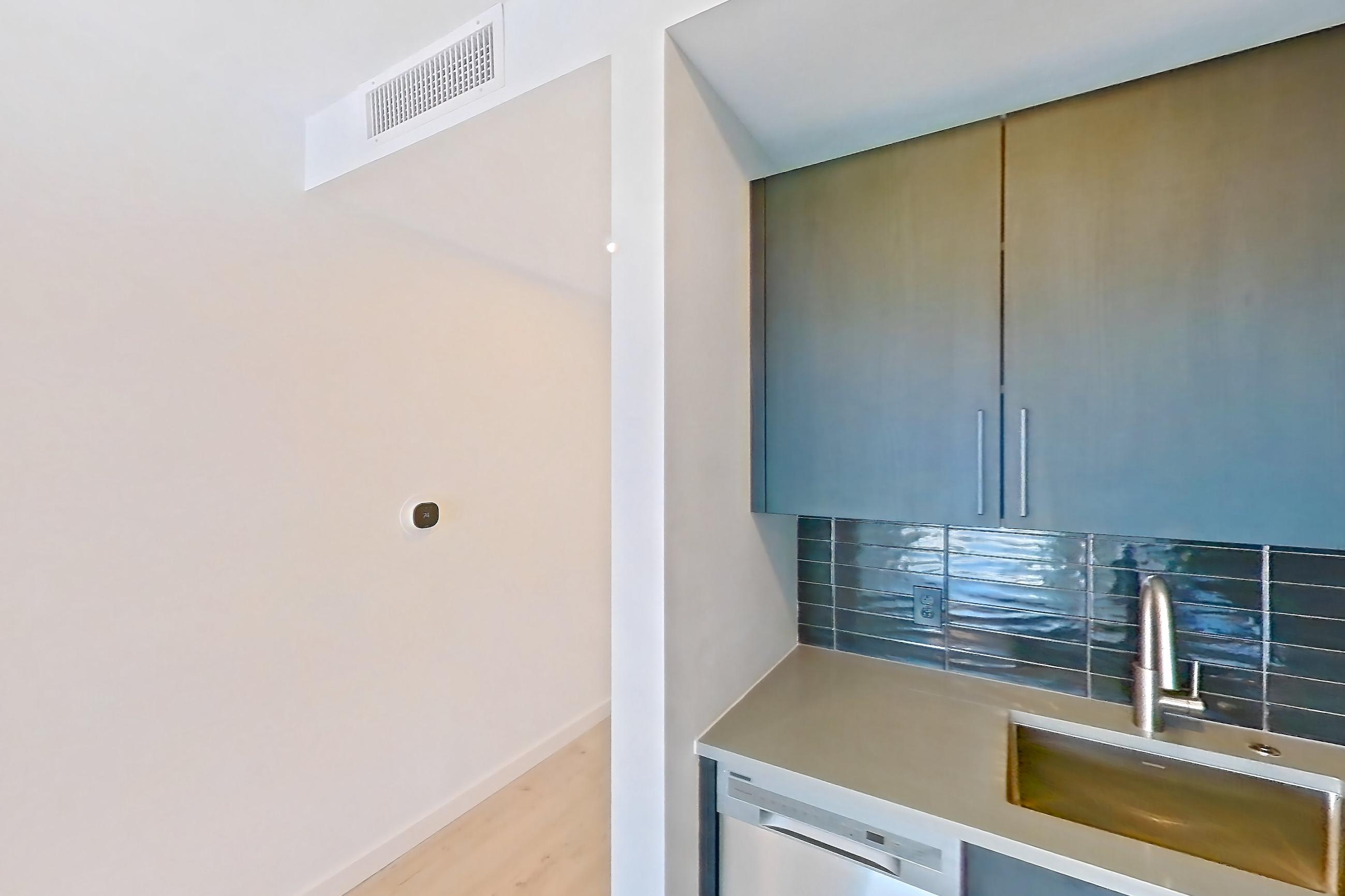 Kitchen with dishwasher, electric range, light countertops, light wood-finish flooring, microwave, oven/range, refrigerator, stainless steel appliances, and white appliances, Apartment 518 at The Citizen