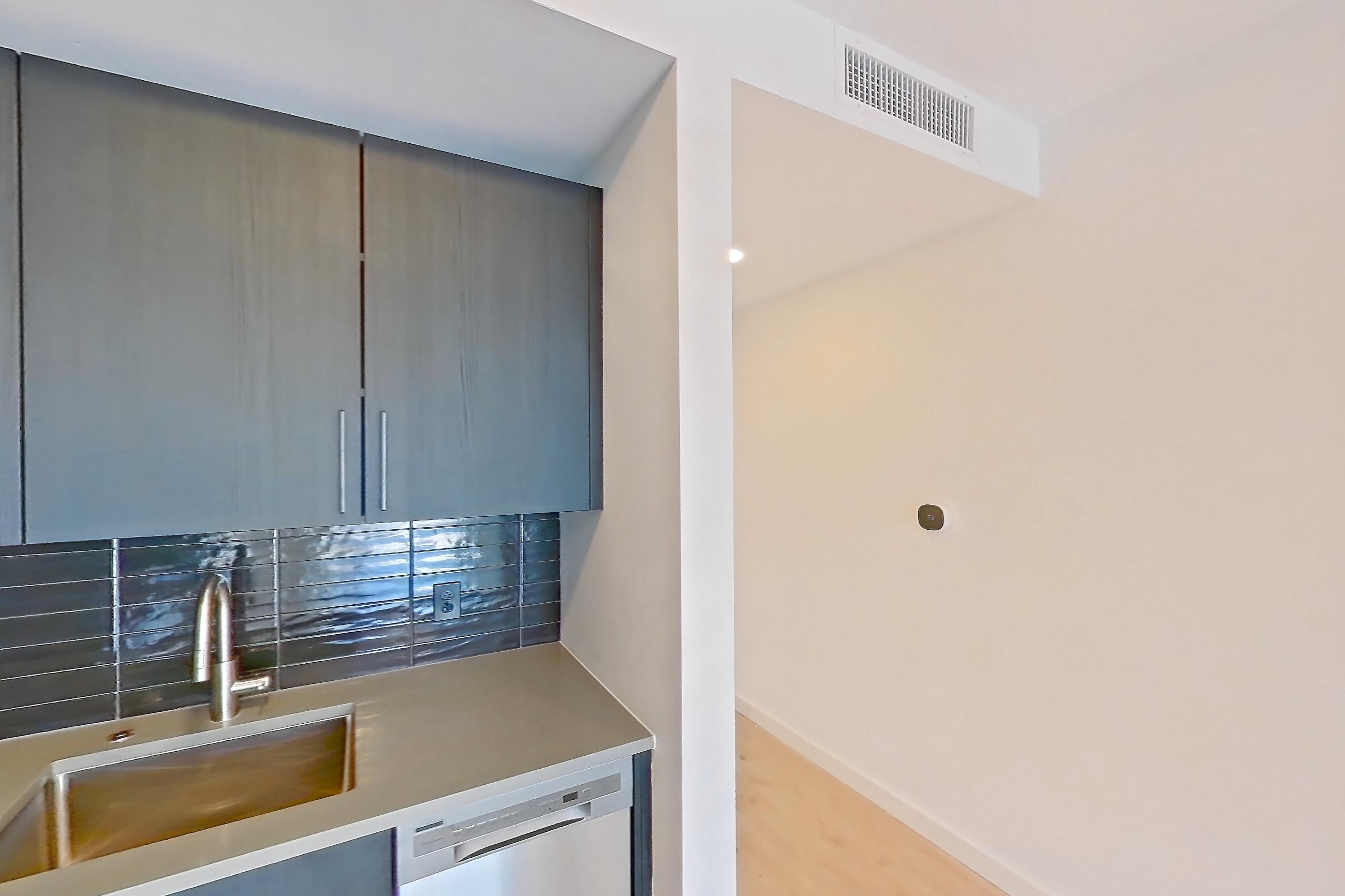 Kitchen with dishwasher, electric range, light countertops, light wood-finish flooring, microwave, oven/range, refrigerator, stainless steel appliances, and white appliances, Apartment 520 at The Citizen