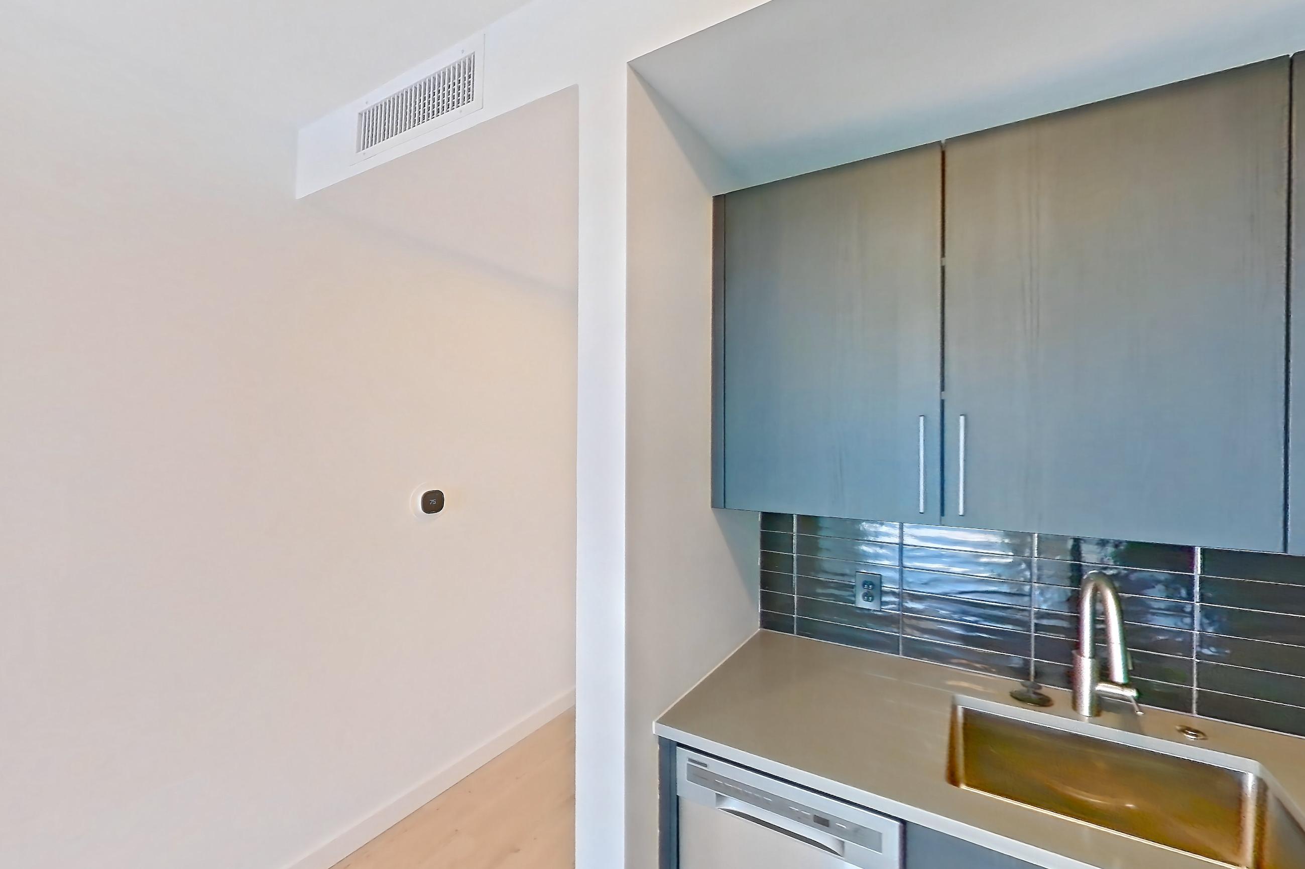 Kitchen with dishwasher, electric range, light countertops, light wood-finish flooring, microwave, oven/range, refrigerator, stainless steel appliances, and white appliances, Apartment 609 at The Citizen