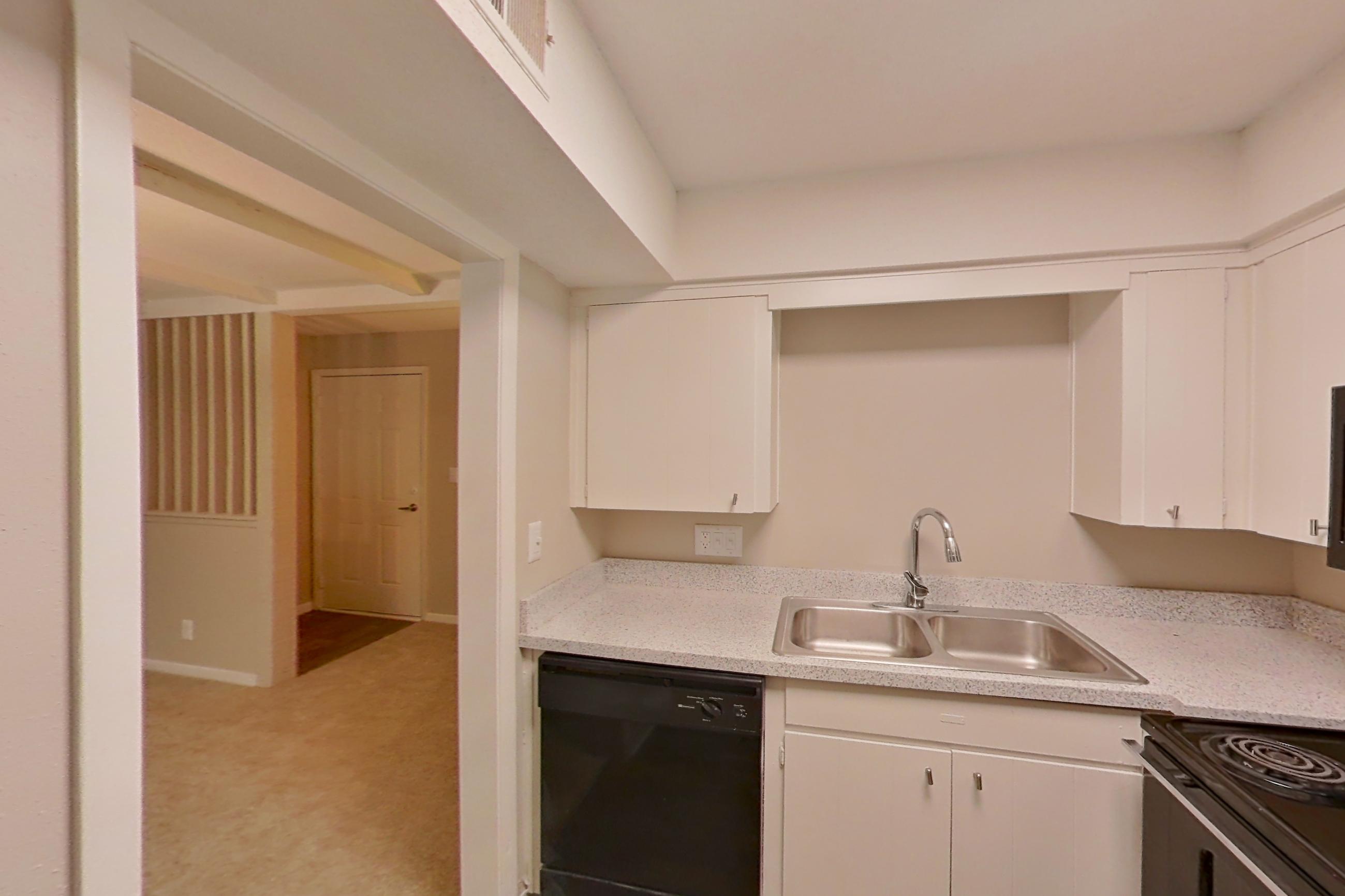 Kitchen with black appliances, dishwasher, electric range, light countertops, light wood-finish flooring, microwave, oven/range, and refrigerator, Apartment 1510C at The Life at Legacy Fountains