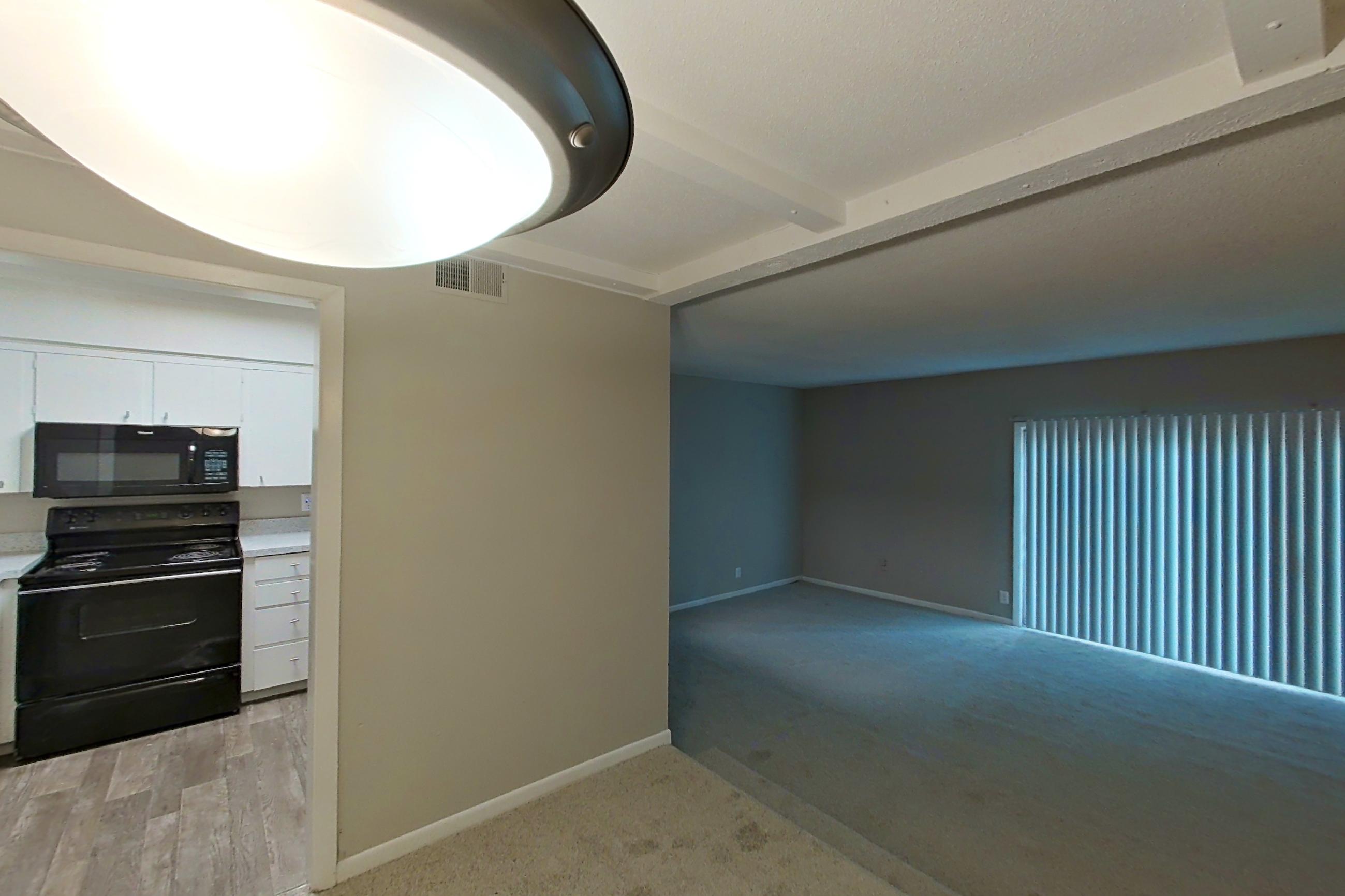 Living space with black appliances, electric range, light carpet, and oven/range, Apartment 1510C at The Life at Legacy Fountains