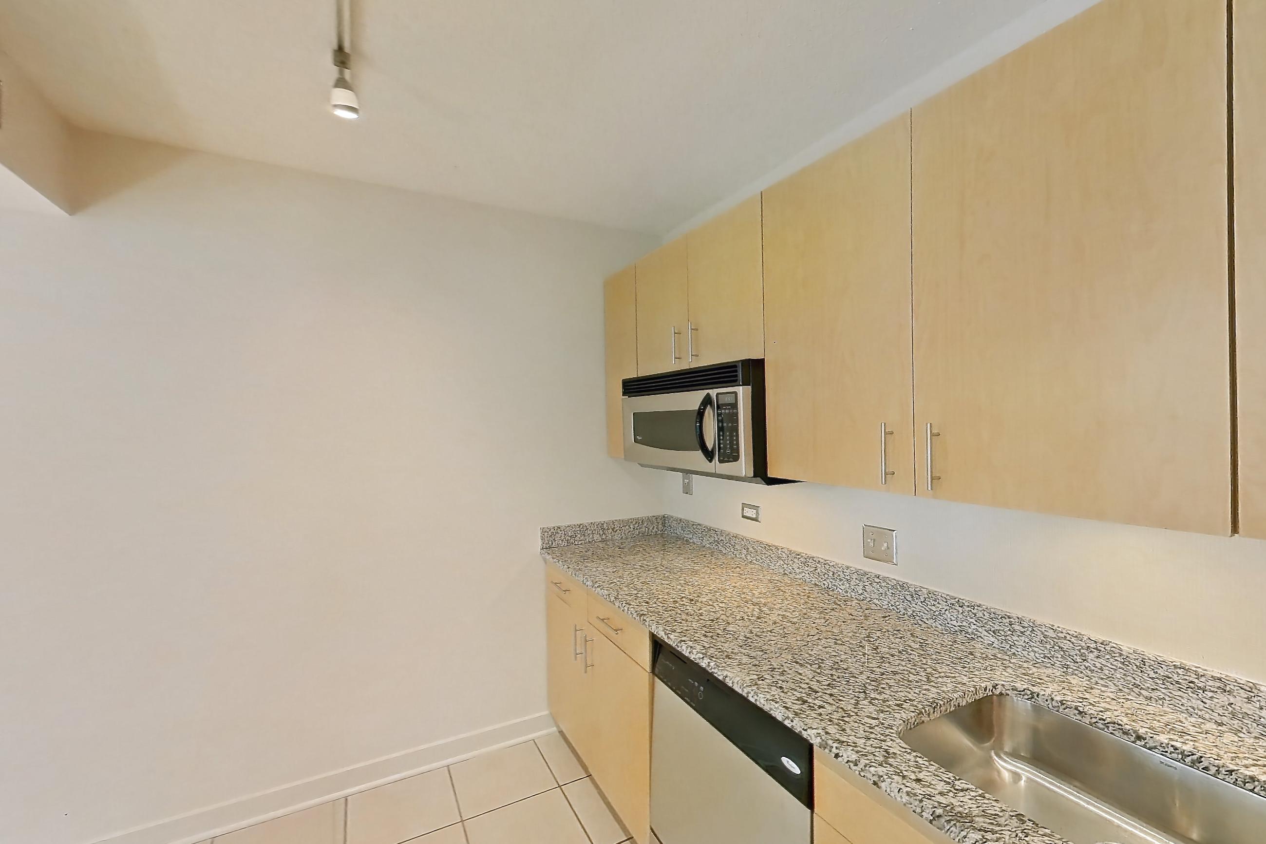 Kitchen with dishwasher, electric range, light stone countertops, light tile flooring, microwave, oven/range, refrigerator, stainless steel appliances, and white appliances, Apartment 00-0305 at Sky55