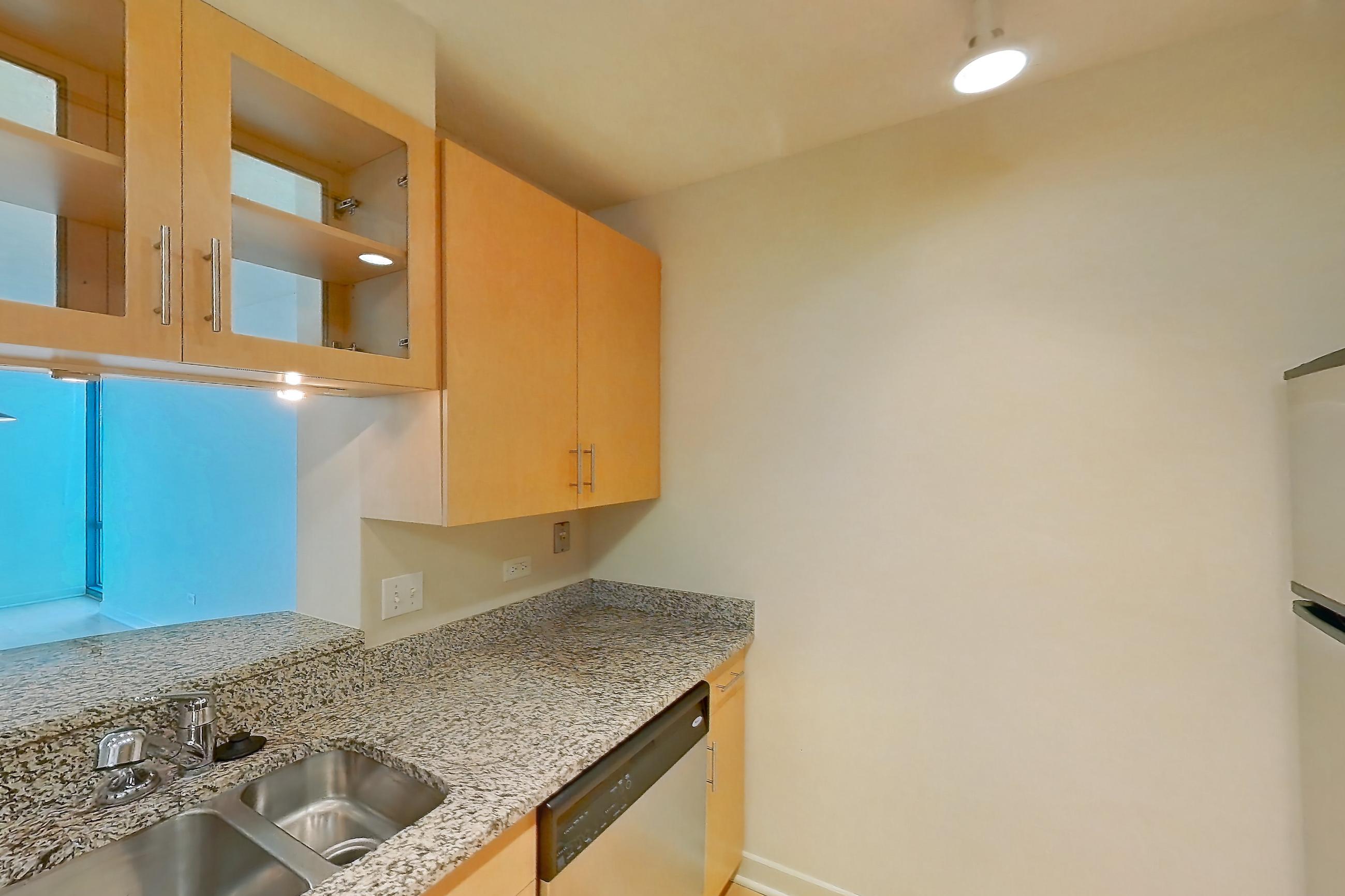Kitchen with dishwasher, electric range, light countertops, light stone countertops, light wood-finish flooring, oven/range, refrigerator, and stainless steel appliances, Apartment 00-1404 at Sky55
