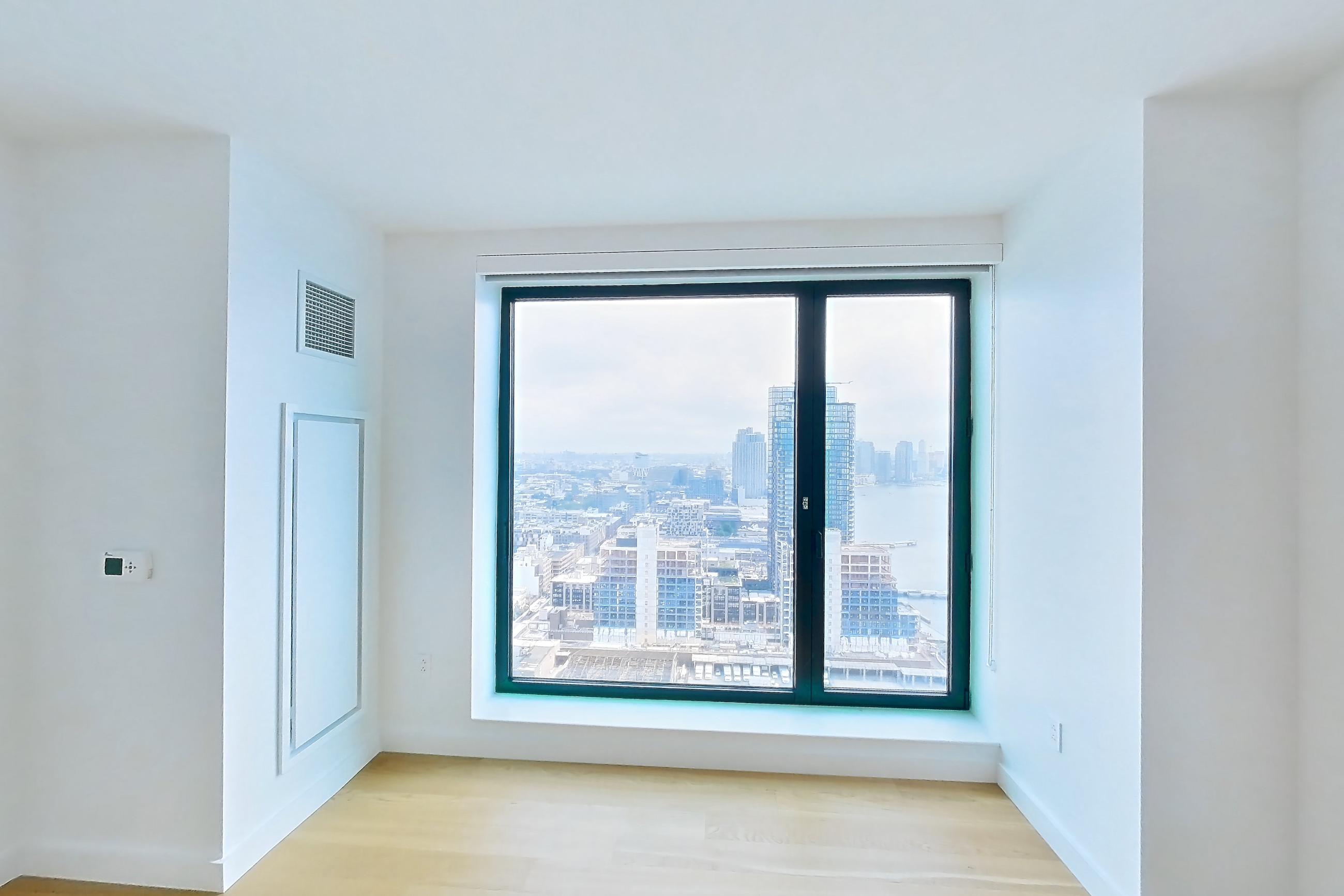 Living room with city view and light wood-finish flooring, Apartment 1-3111 at Eagle + West