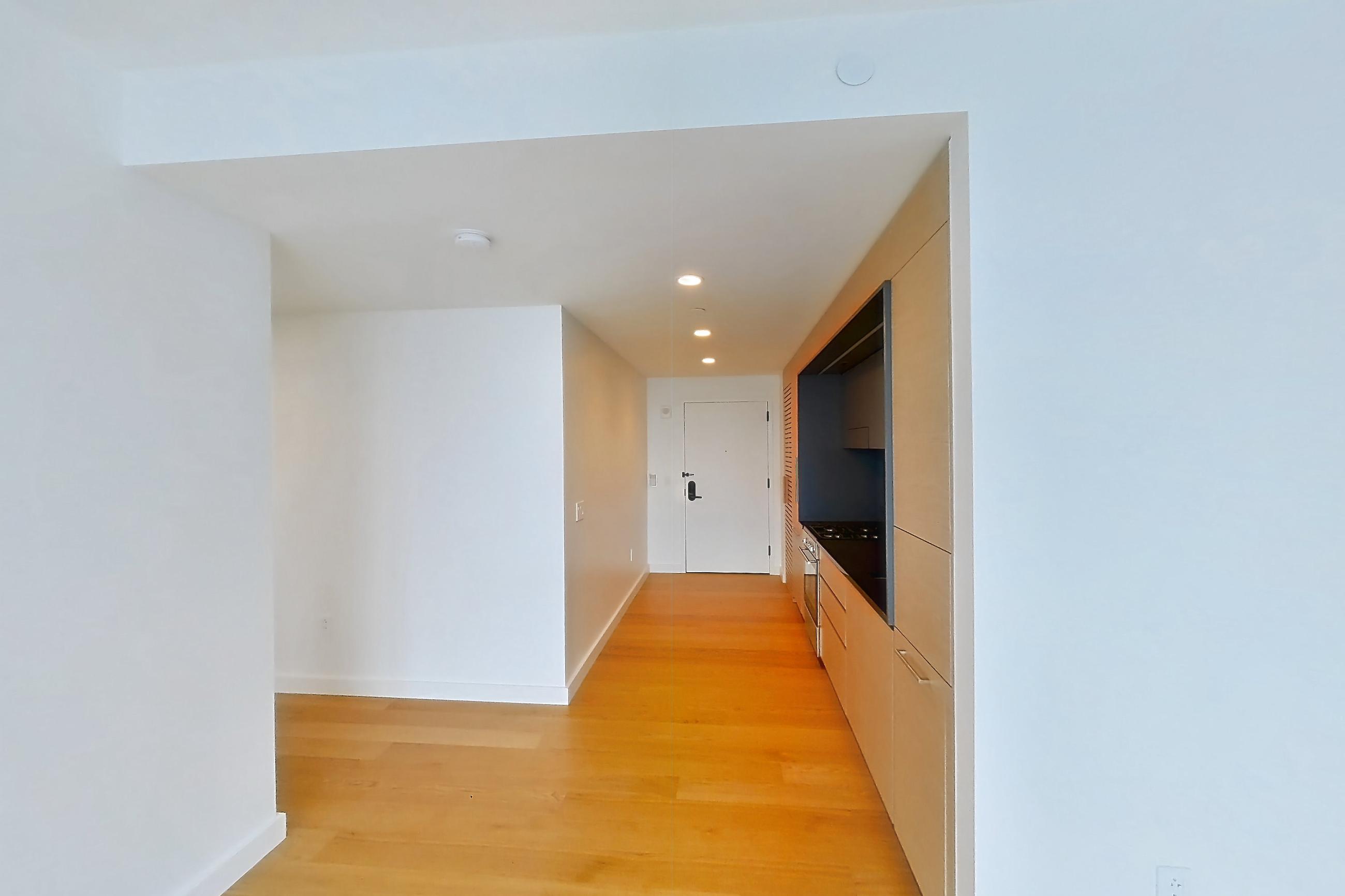 Living room with city view and light wood-finish flooring, Apartment 1-3111 at Eagle + West