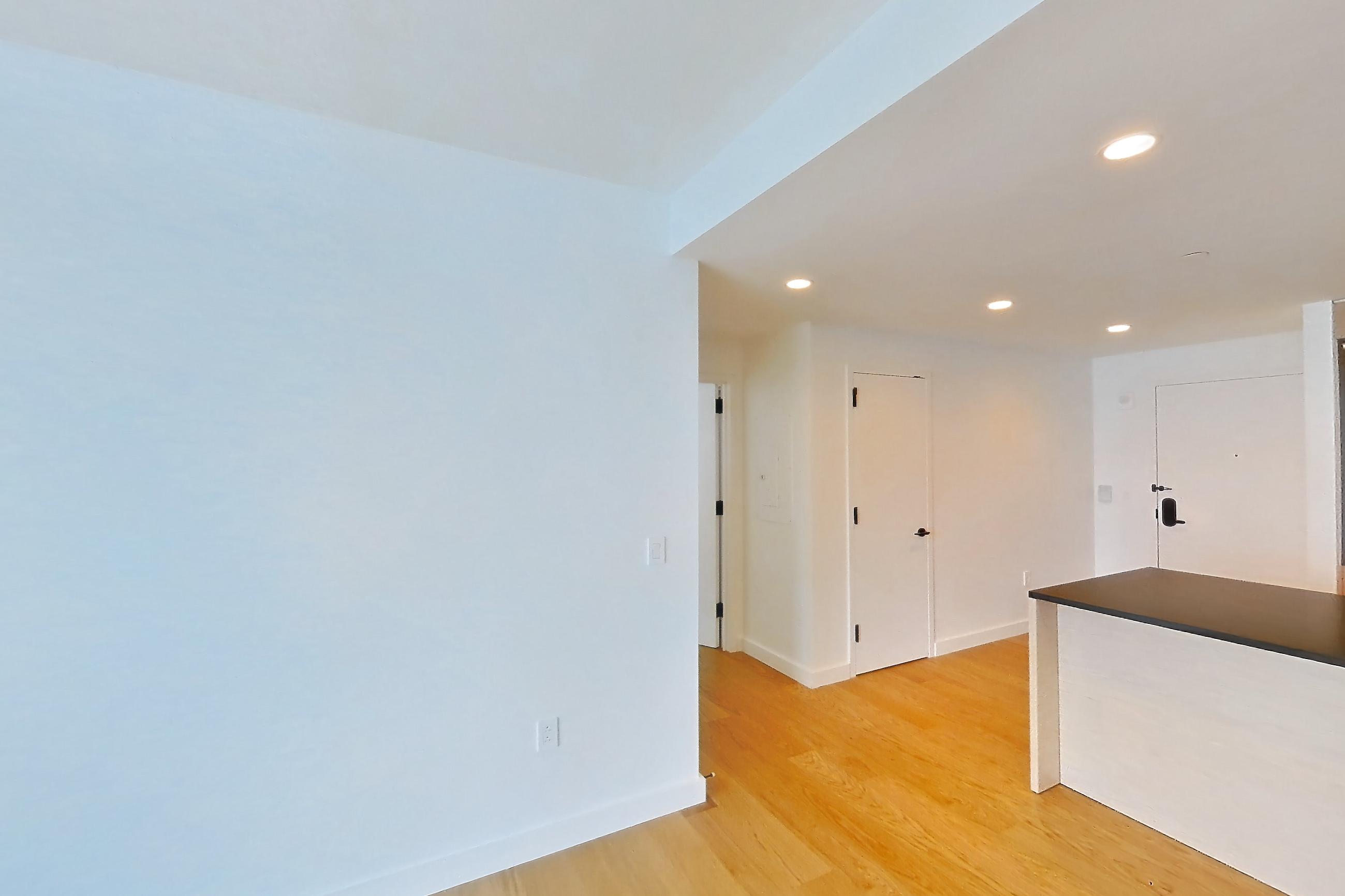Living room with light wood-finish flooring, Apartment 1-3107 at Eagle + West