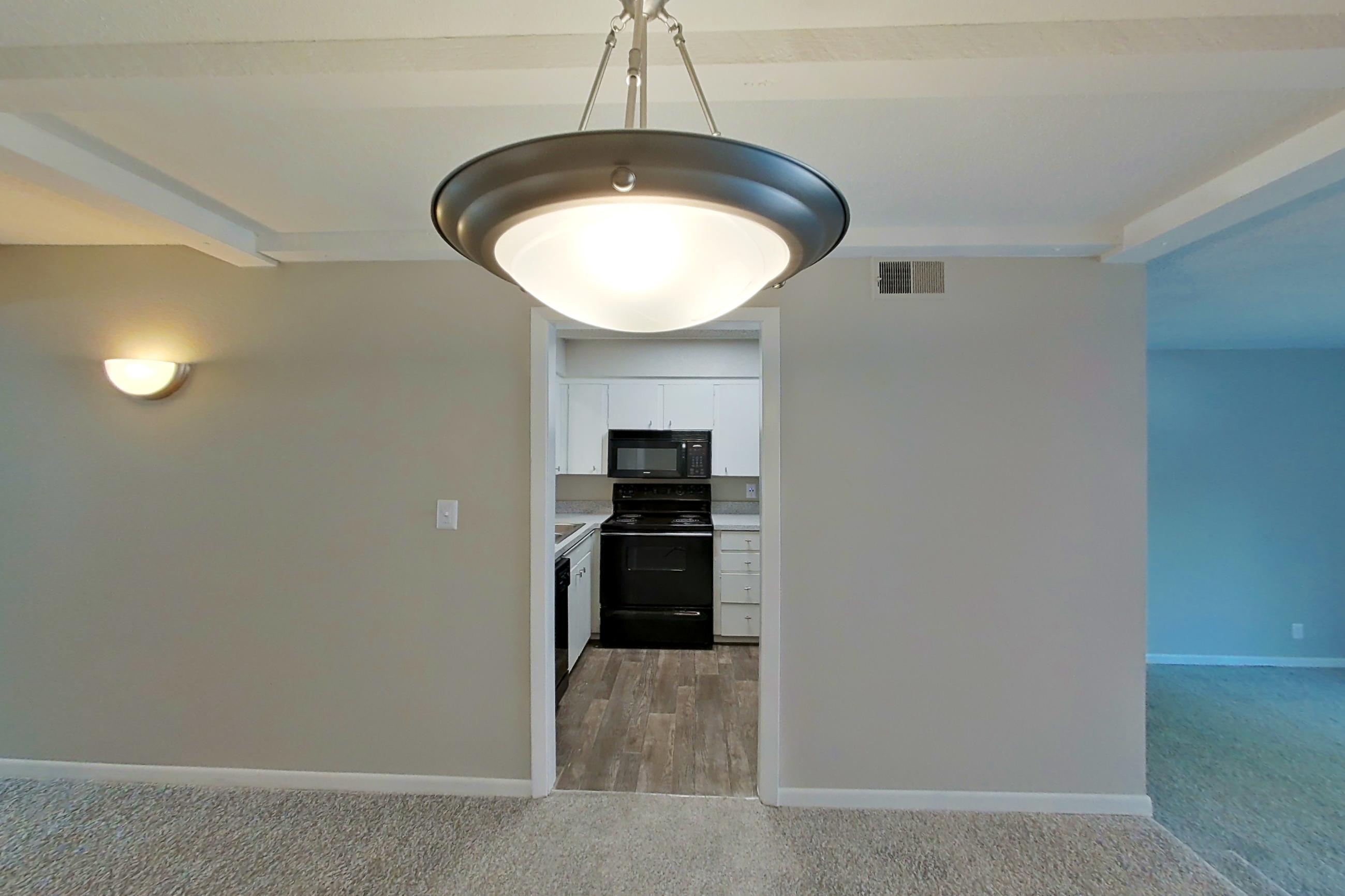 Living space with black appliances, electric range, light carpet, and oven/range, Apartment 1524C at The Life at Legacy Fountains