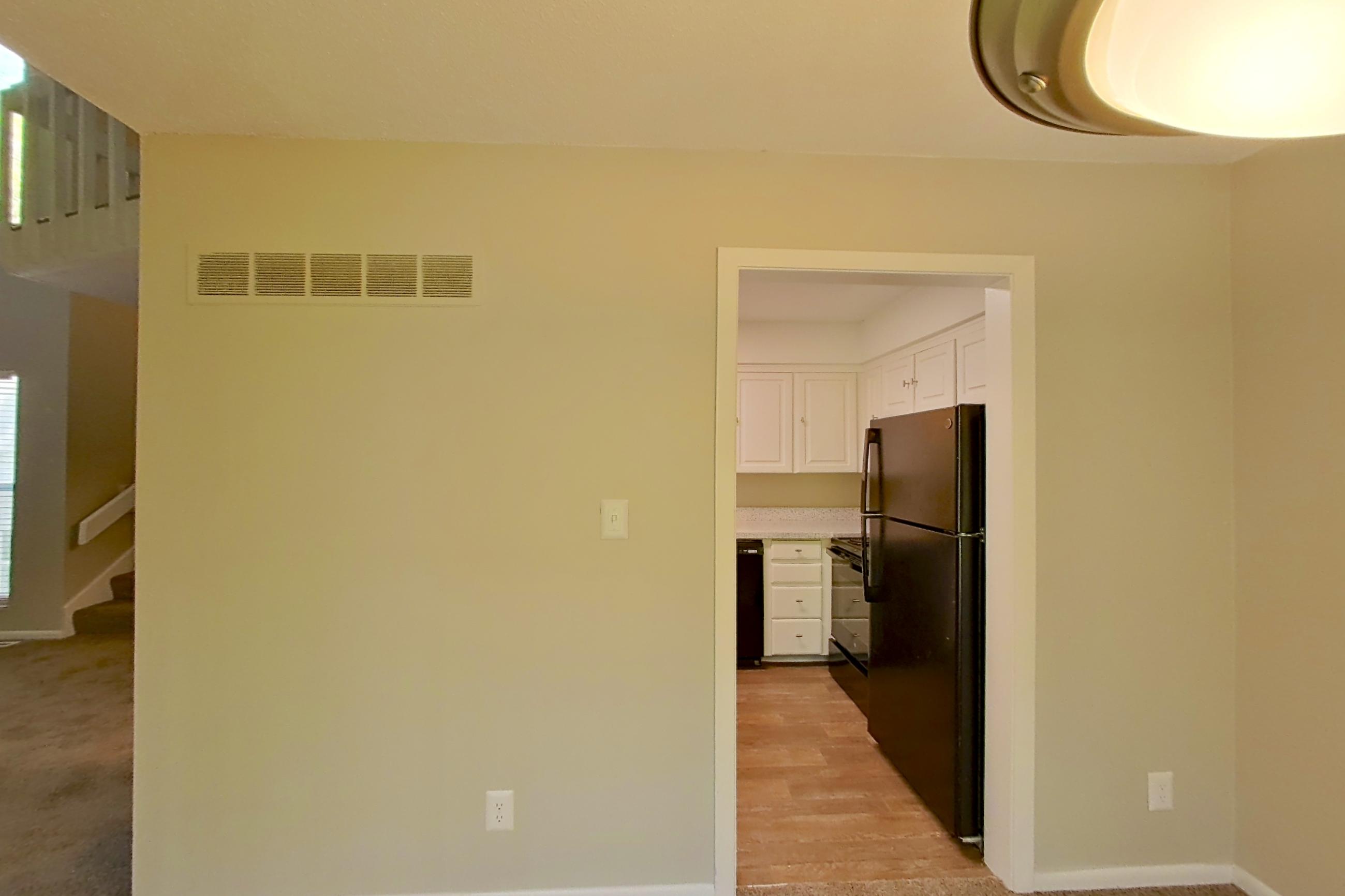 Dining room with black appliances, brick fireplace, dishwasher, fireplace, and refrigerator, Apartment 1415 at The Life at Legacy Fountains