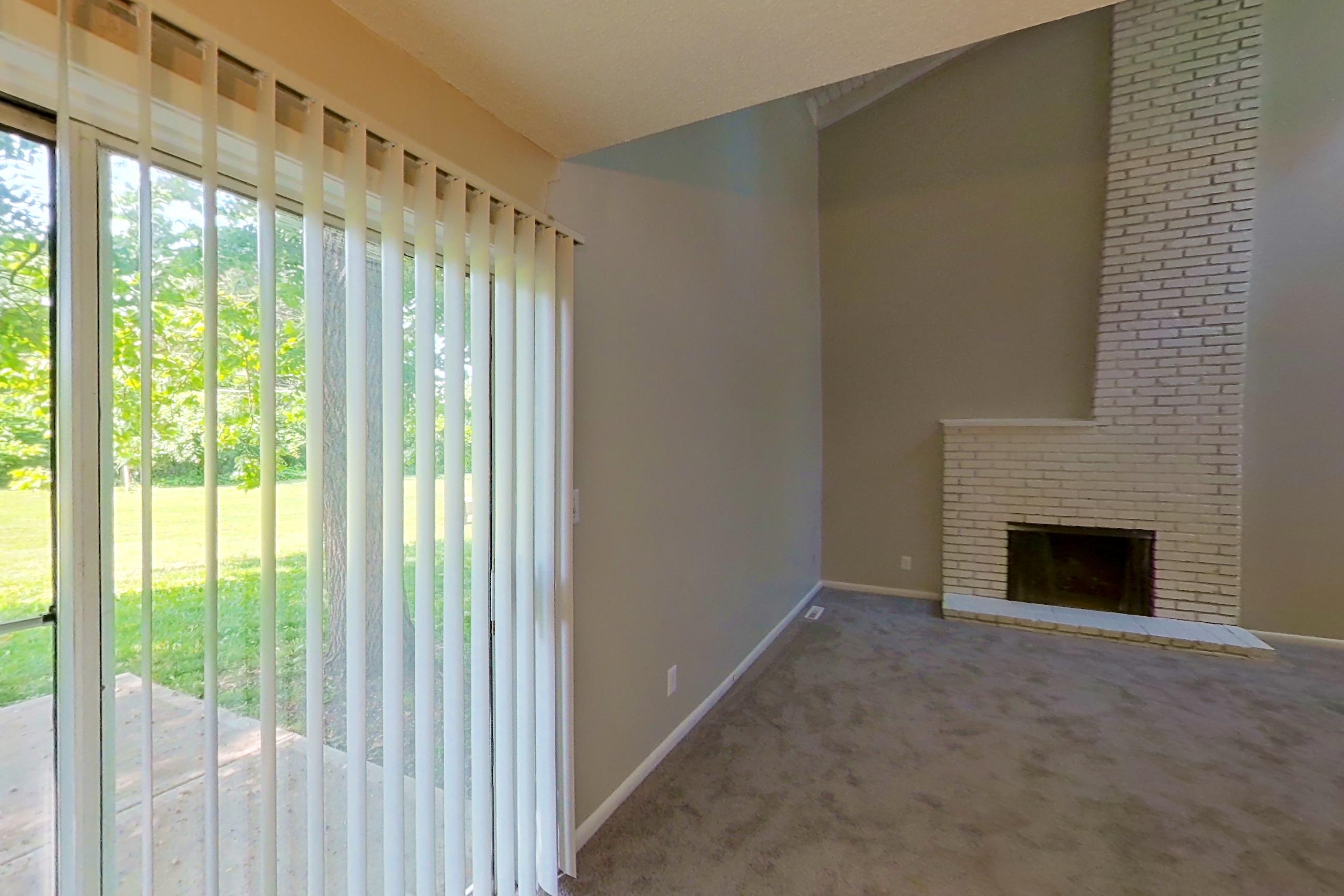 Dining room with black appliances, brick fireplace, dishwasher, fireplace, and refrigerator, Apartment 1415 at The Life at Legacy Fountains