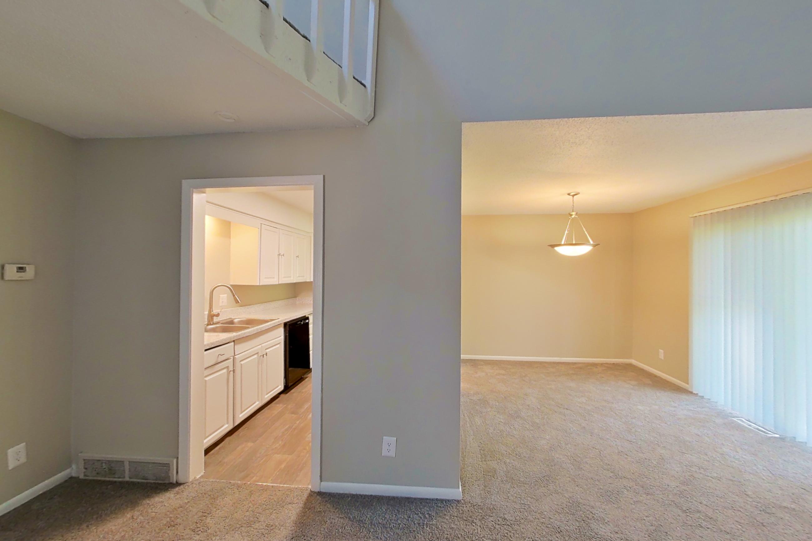 Living room with black appliances, dishwasher, fireplace, light carpet, and tile fireplace, Apartment 1415 at The Life at Legacy Fountains