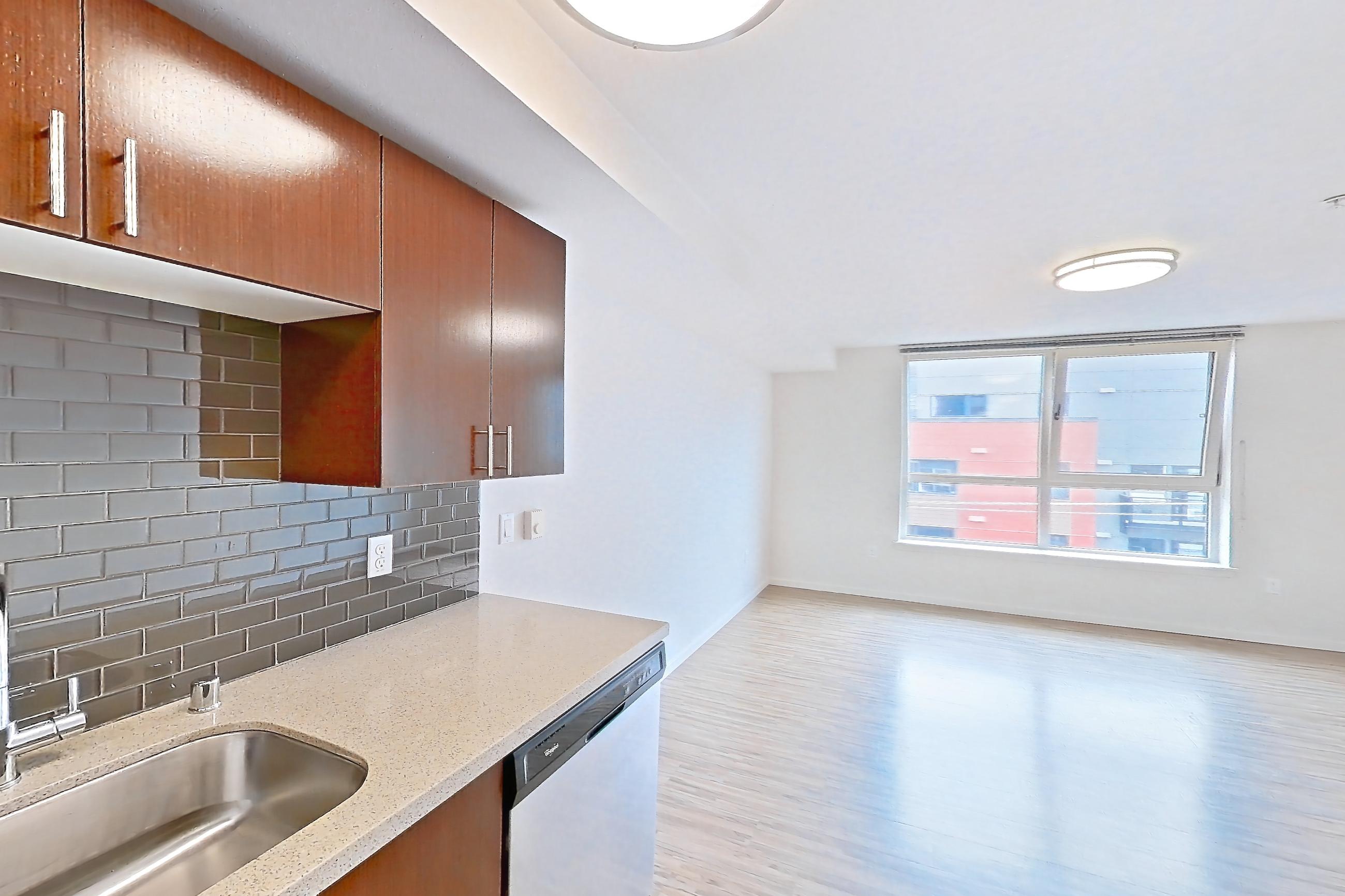 Kitchen with dishwasher, electric range, light stone countertops, light wood-finish flooring, microwave, oven/range, refrigerator, and stainless steel appliances, Unit L643 at Union SLU