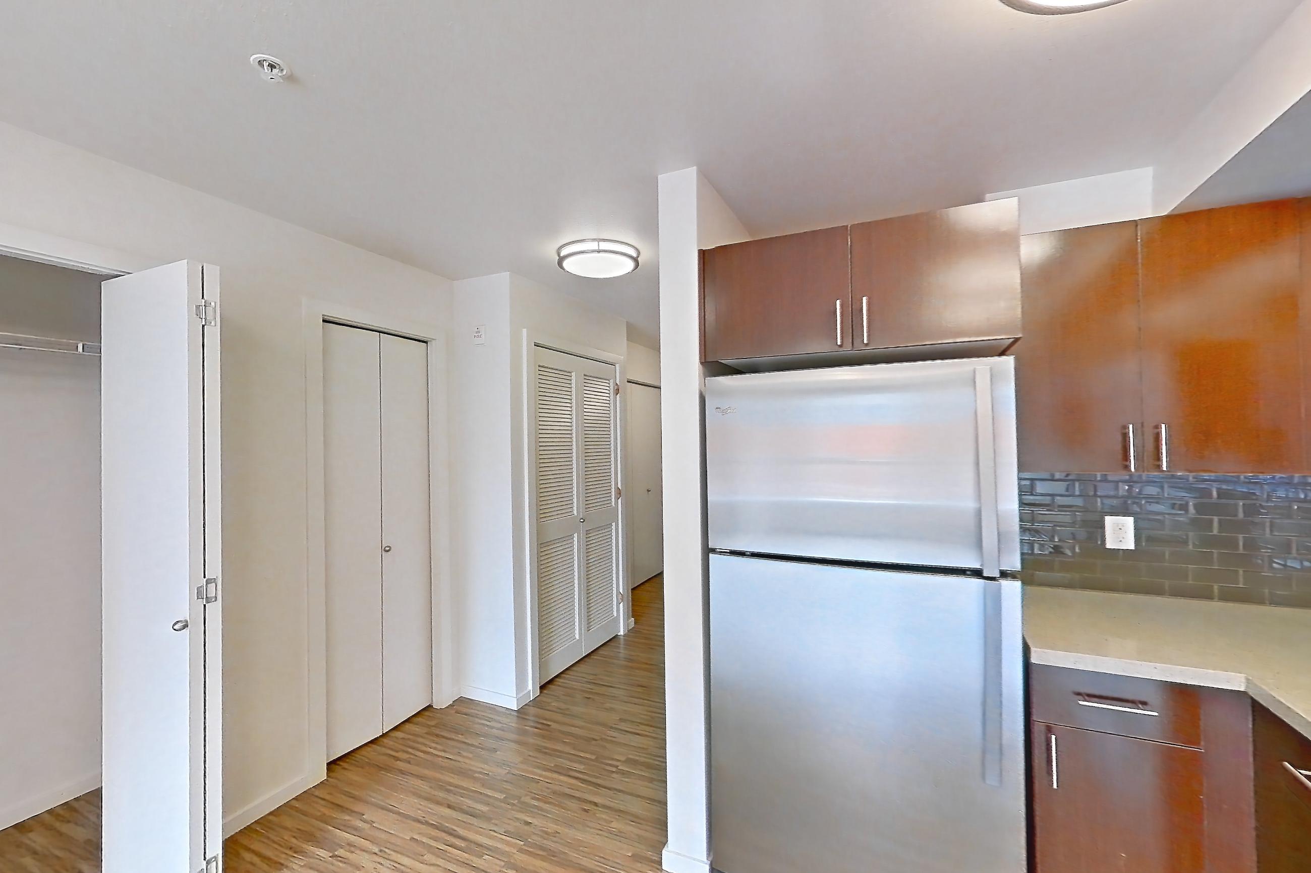 Kitchen with dishwasher, electric range, light stone countertops, light wood-finish flooring, microwave, oven/range, refrigerator, and stainless steel appliances, Unit L643 at Union SLU