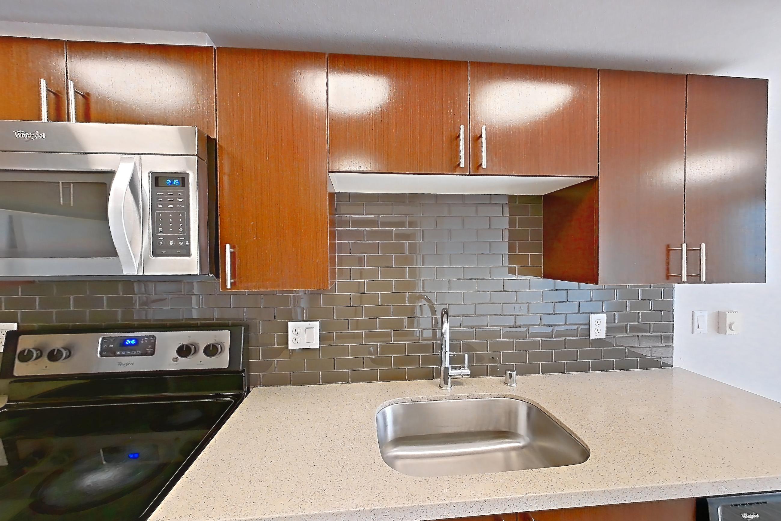 Kitchen with dishwasher, electric range, light stone countertops, light wood-finish flooring, microwave, oven/range, refrigerator, and stainless steel appliances, Unit L643 at Union SLU