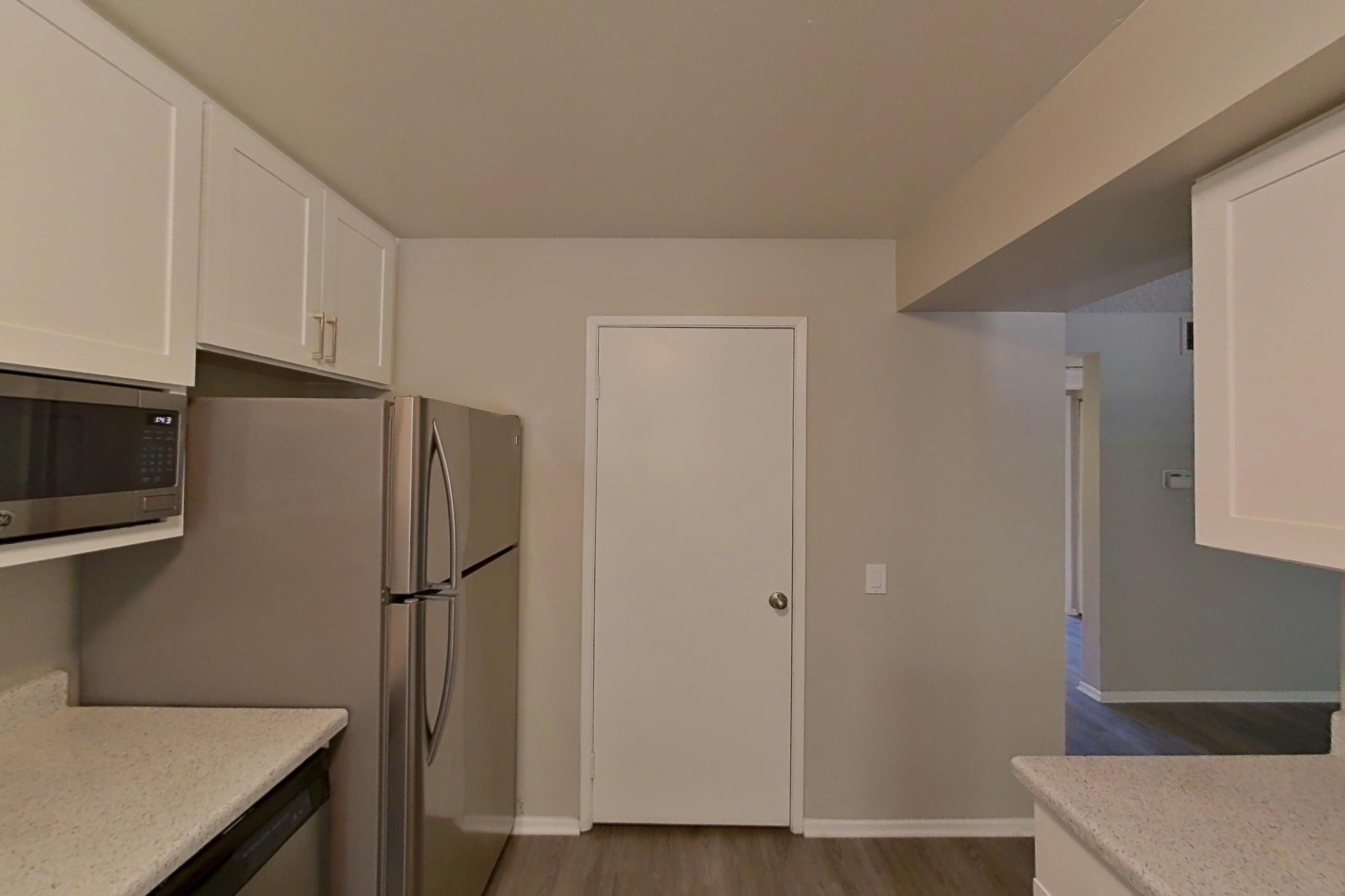 Kitchen with dishwasher, electric range, light countertops, light stone countertops, oven/range, refrigerator, and stainless steel appliances, Apartment 21-01 at Avana Rancho Cucamonga