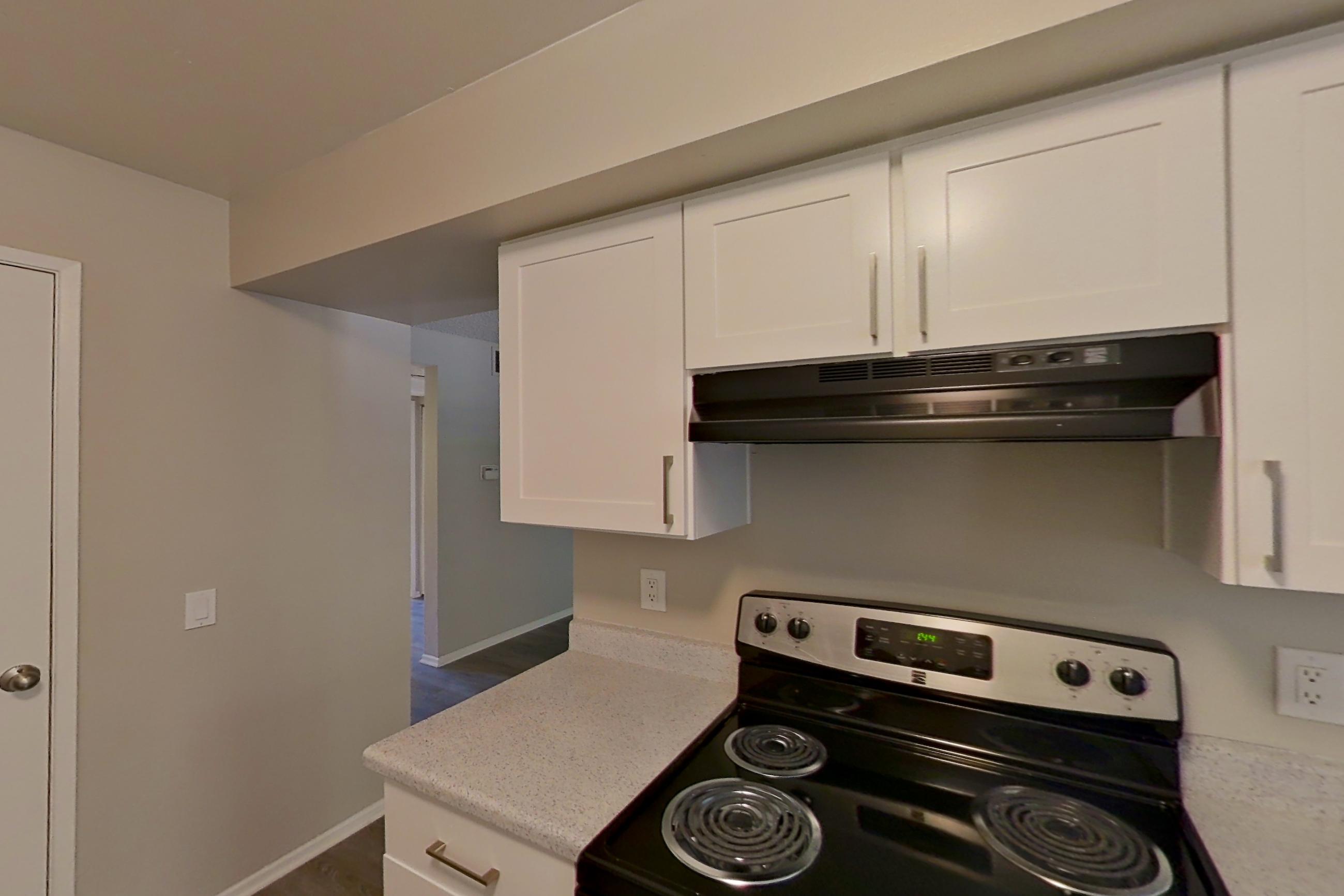 Kitchen with dishwasher, electric range, light countertops, light stone countertops, oven/range, refrigerator, and stainless steel appliances, Apartment 21-01 at Avana Rancho Cucamonga