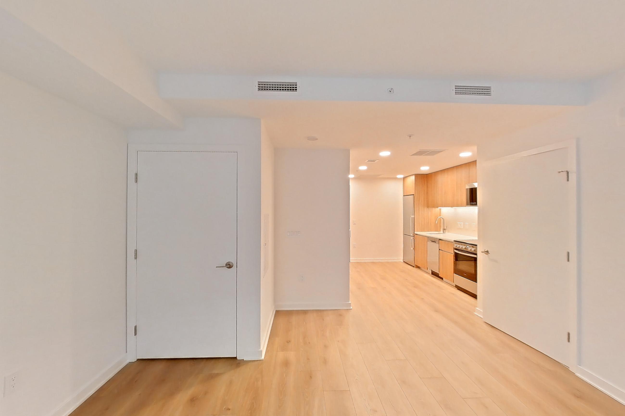 Living space with light wood-finish flooring, Apartment 0406 at The Hale