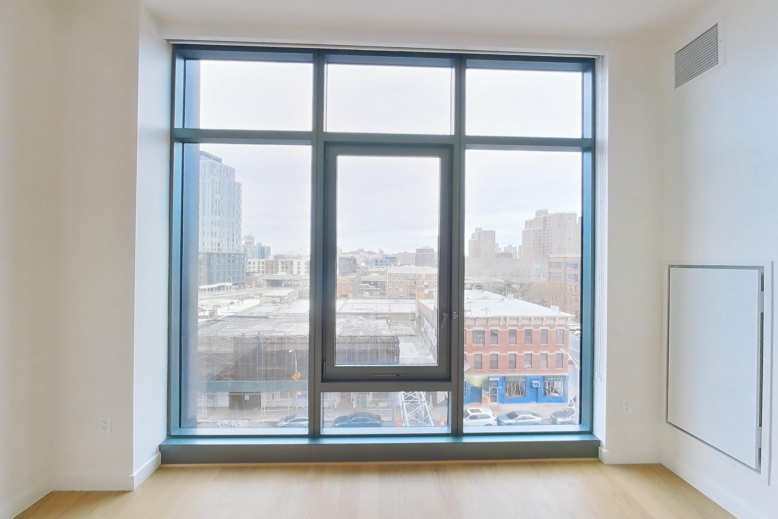 Living space with city view and light wood-finish flooring, Apartment E-0654 at Lincoln at Bankside