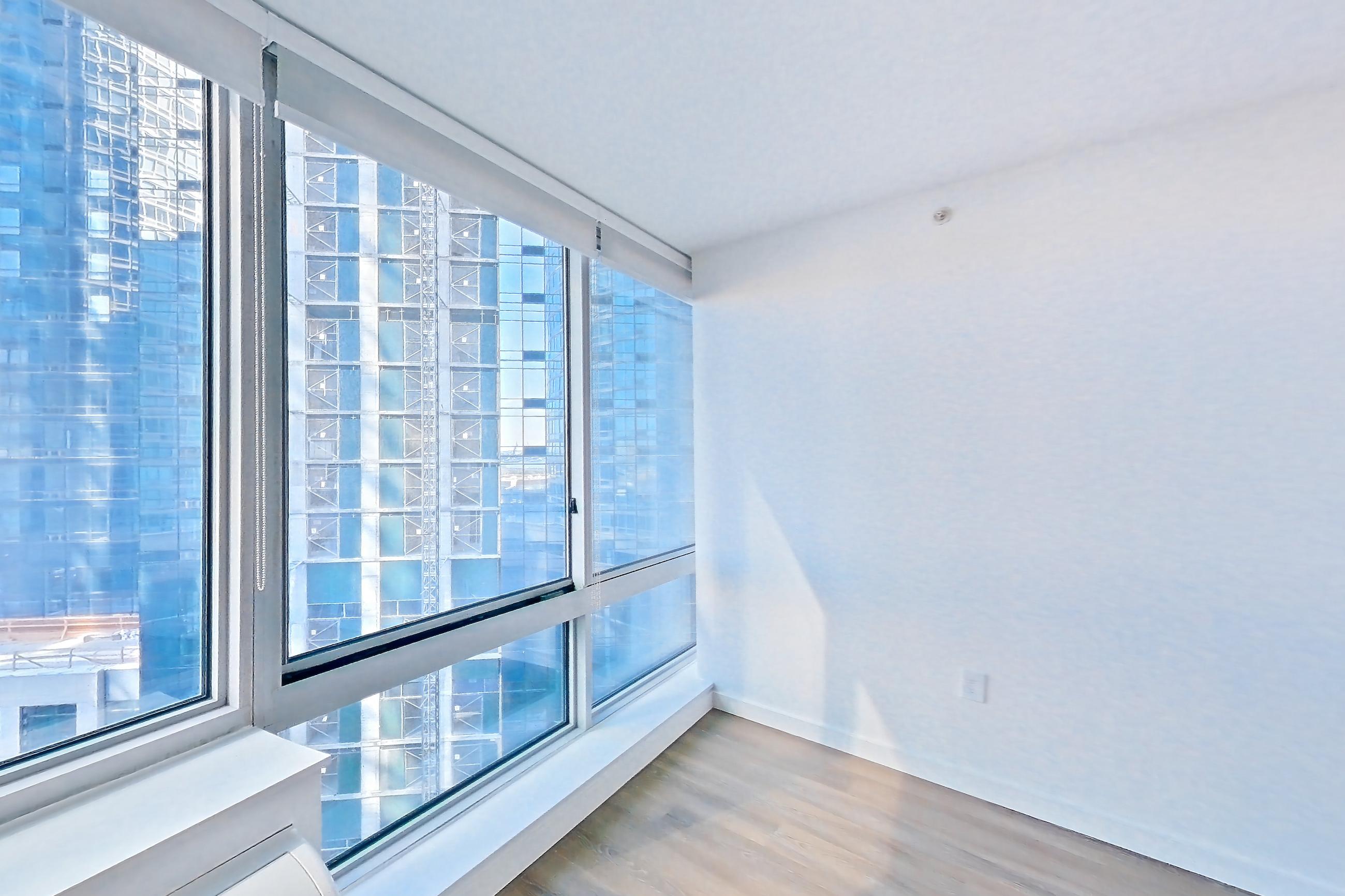 Living room with city view and dark wood-finish flooring, Apartment LT-E1207 at Liberty Towers