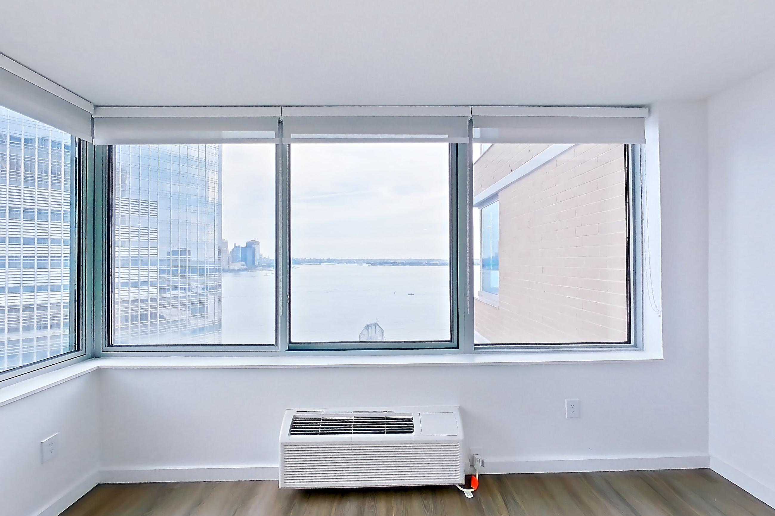 Living room with air conditioning and light wood-finish flooring, Apartment LT-E2203 at Liberty Towers
