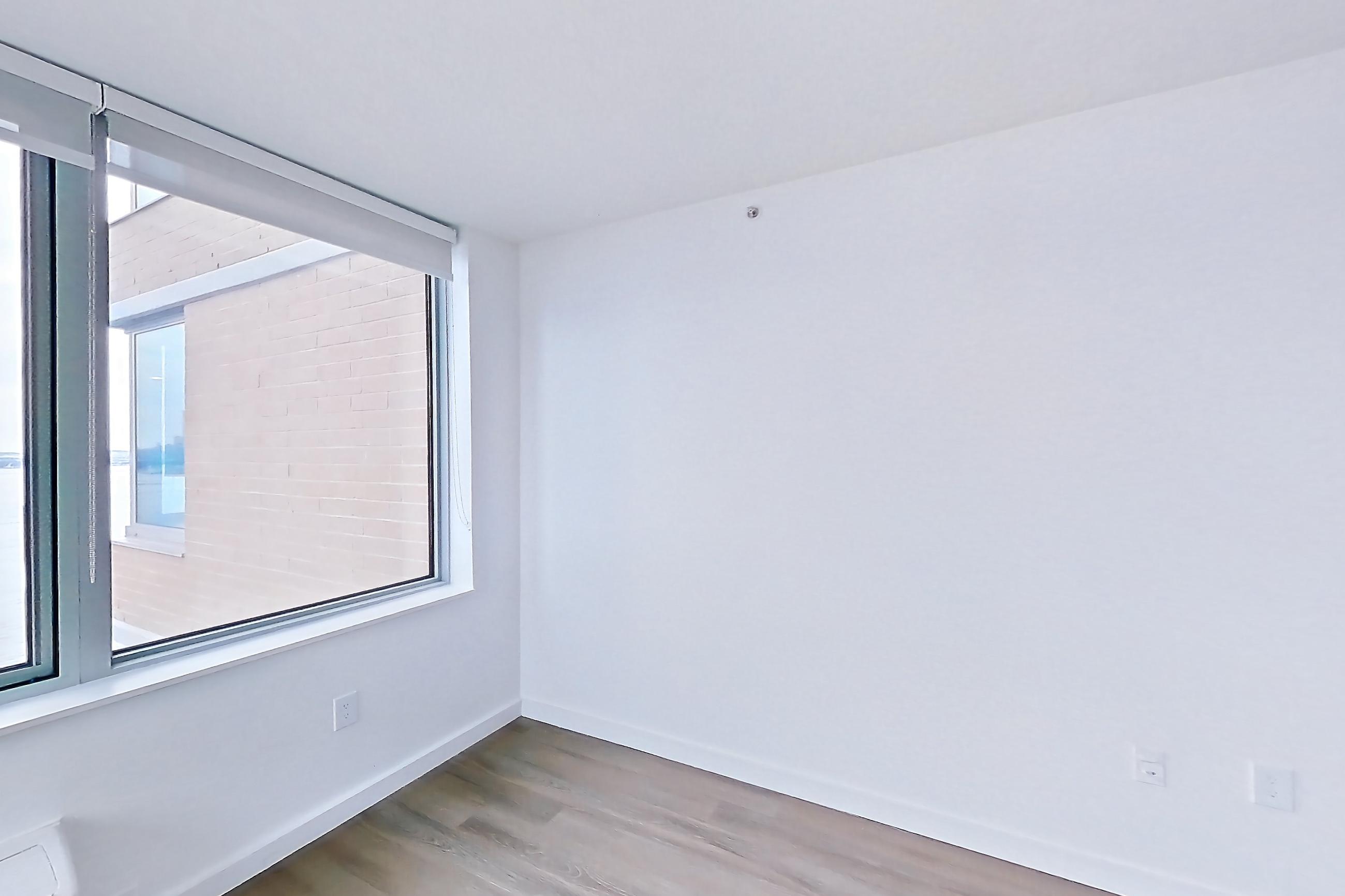 Living room with air conditioning and light wood-finish flooring, Apartment LT-E2203 at Liberty Towers