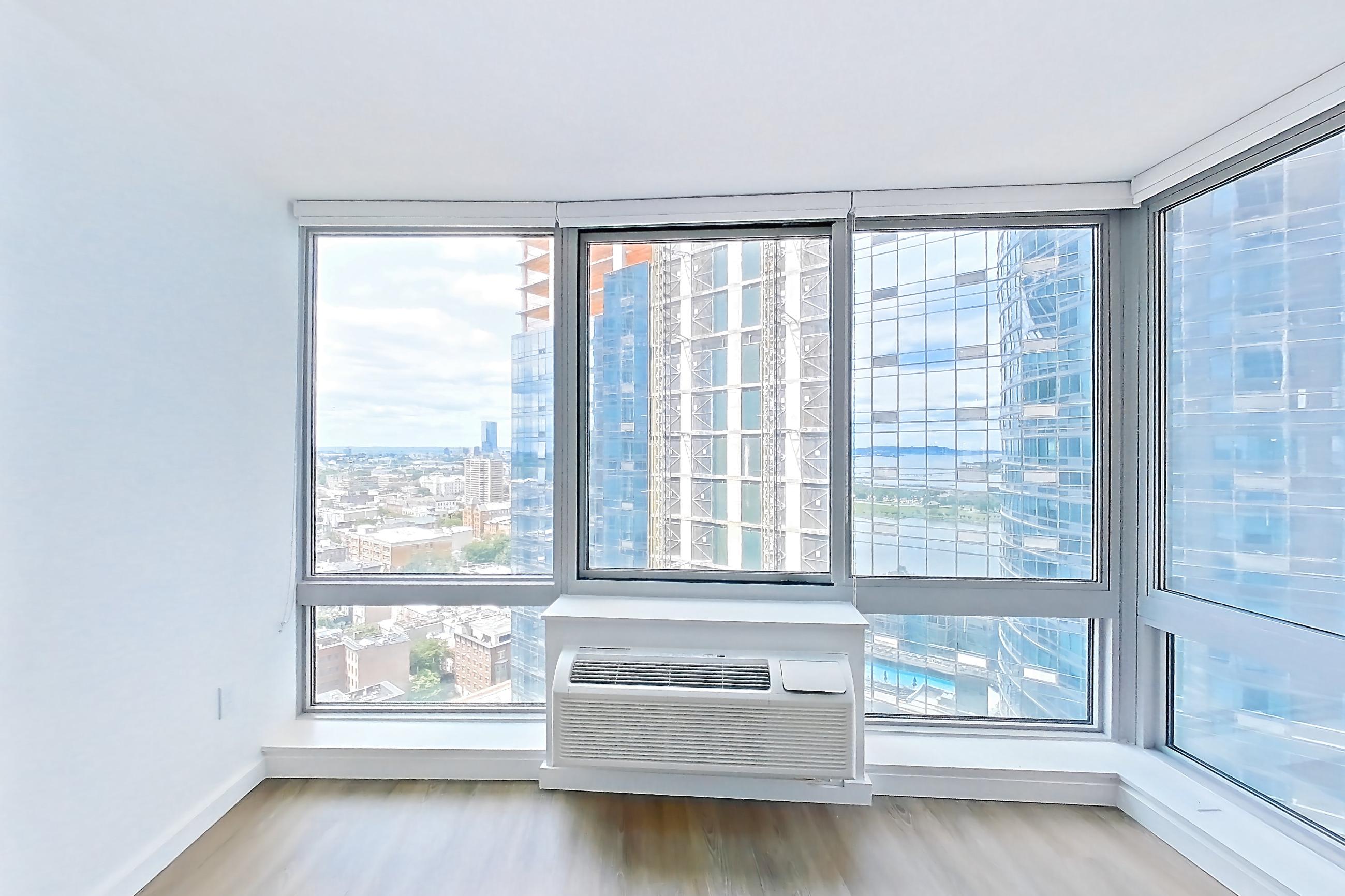 Living room with air conditioning and city view, Apartment LT-E2406 at Liberty Towers