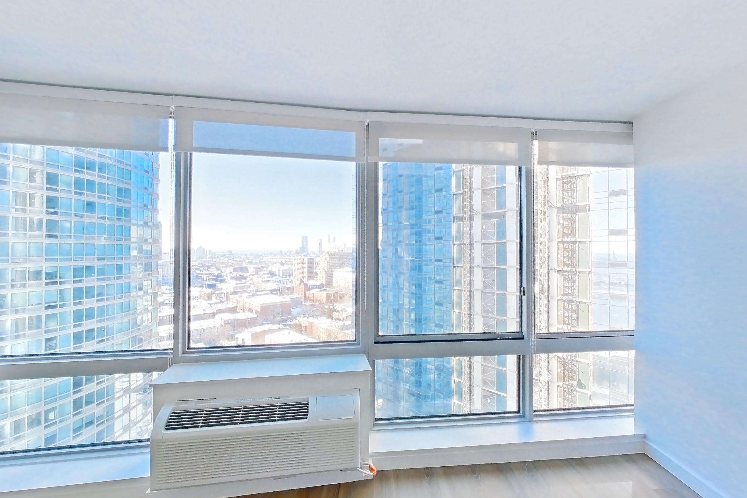 Living room with air conditioning and city view, Apartment LT-E2507 at Liberty Towers