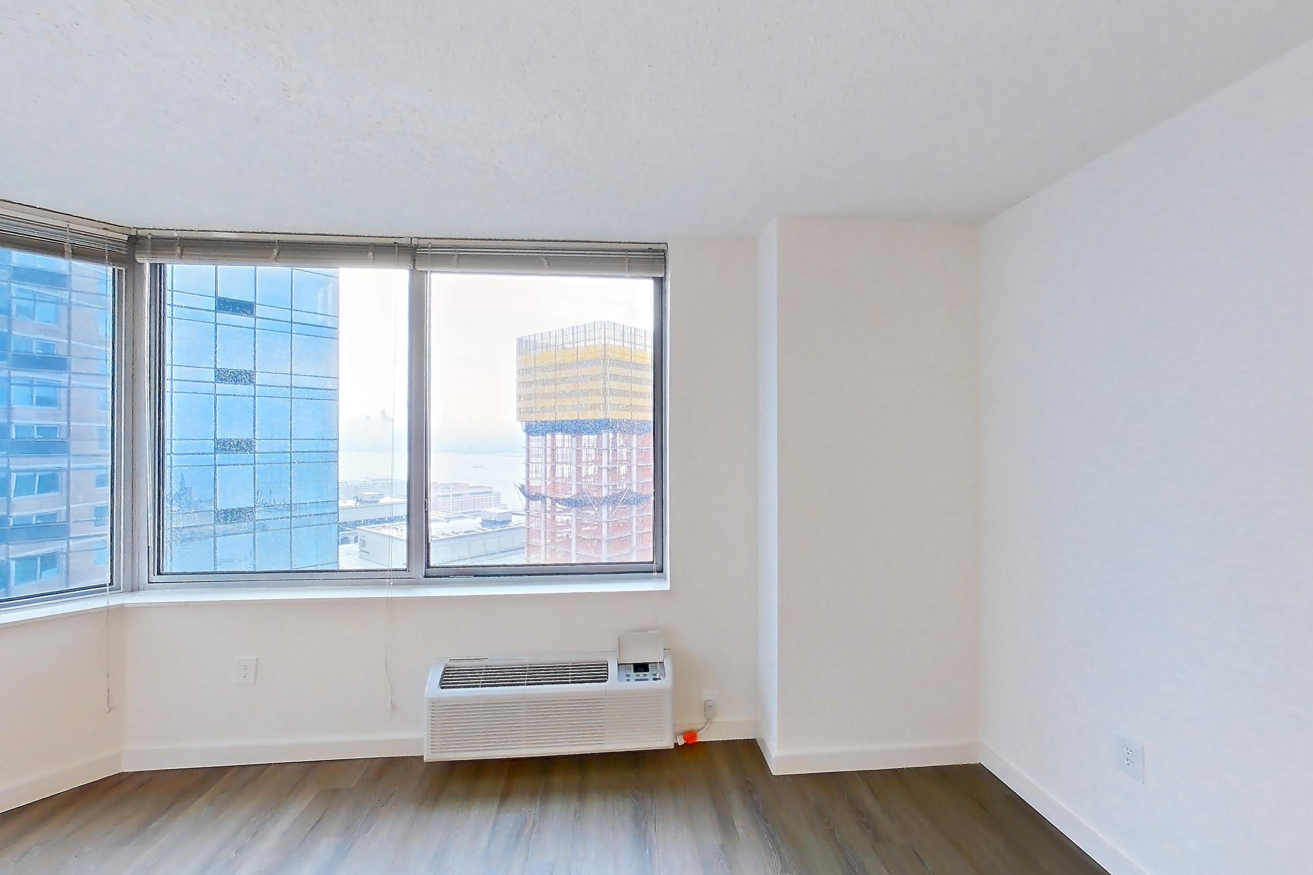 Living room with air conditioning and dark wood-finish flooring, Apartment LT-E2905 at Liberty Towers