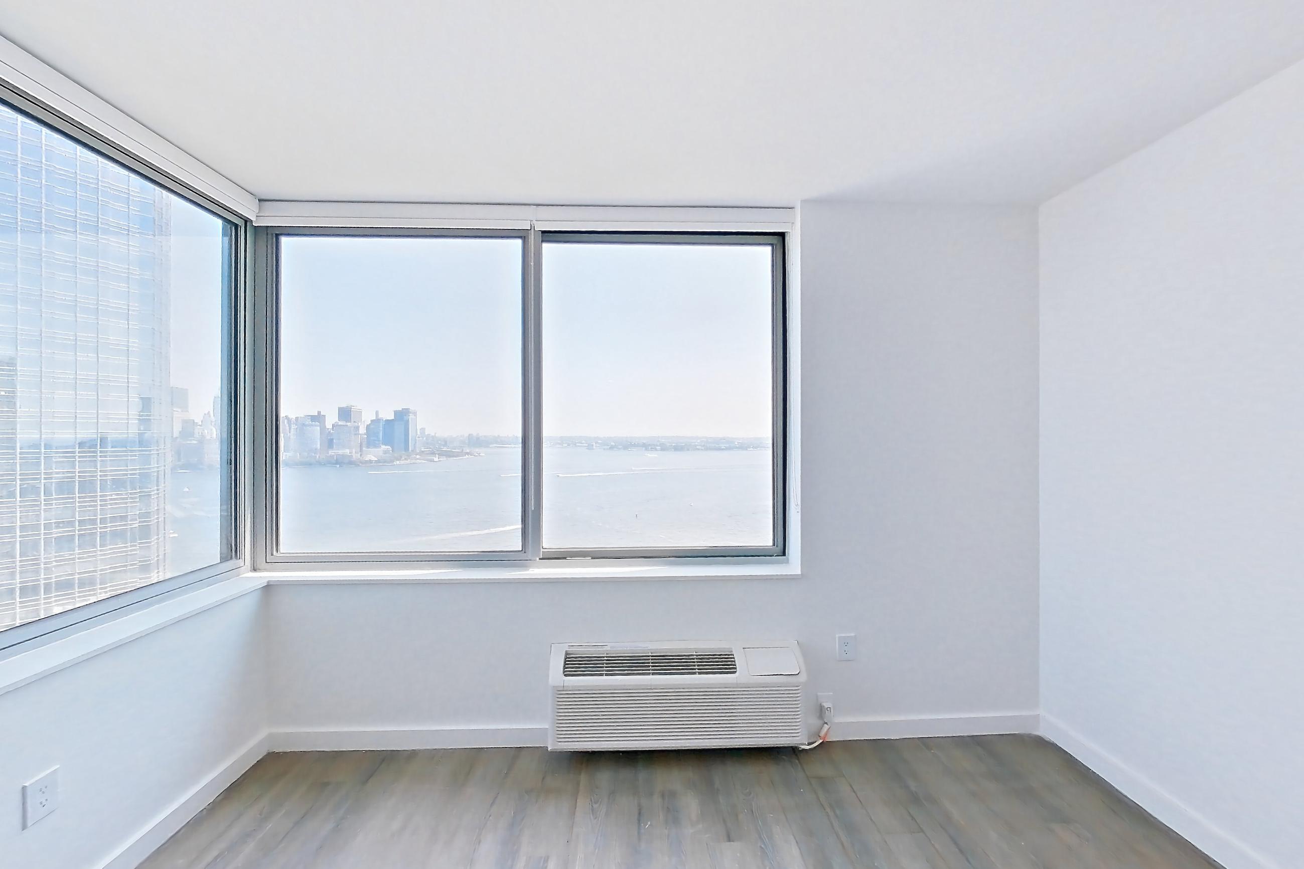 Living room with air conditioning and dark wood-finish flooring, Apartment LT-E3001 at Liberty Towers