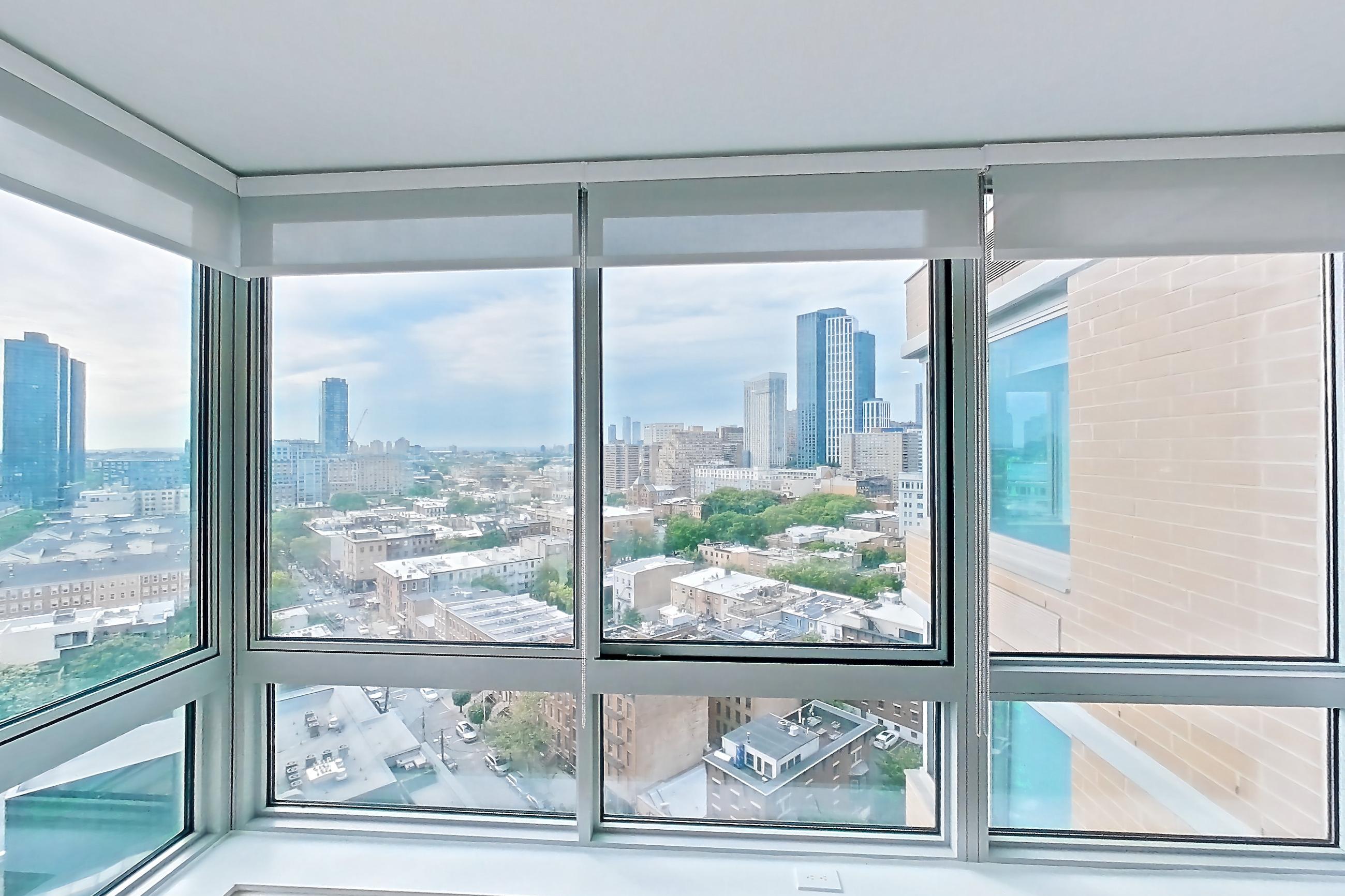 Living room with city view, light wood-finish flooring, and skyline view, Apartment LT-W1804 at Liberty Towers