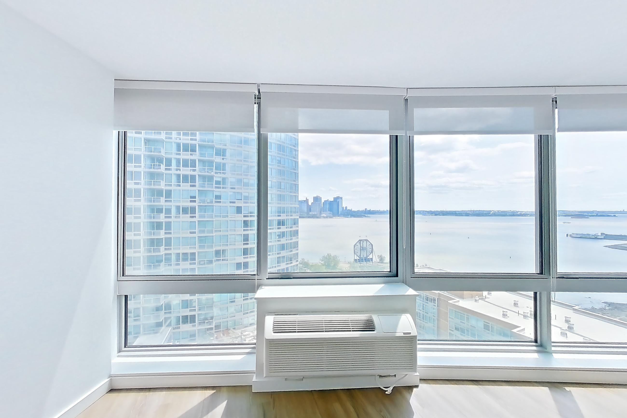 Living room with air conditioning and light wood-finish flooring, Apartment LT-W1811 at Liberty Towers