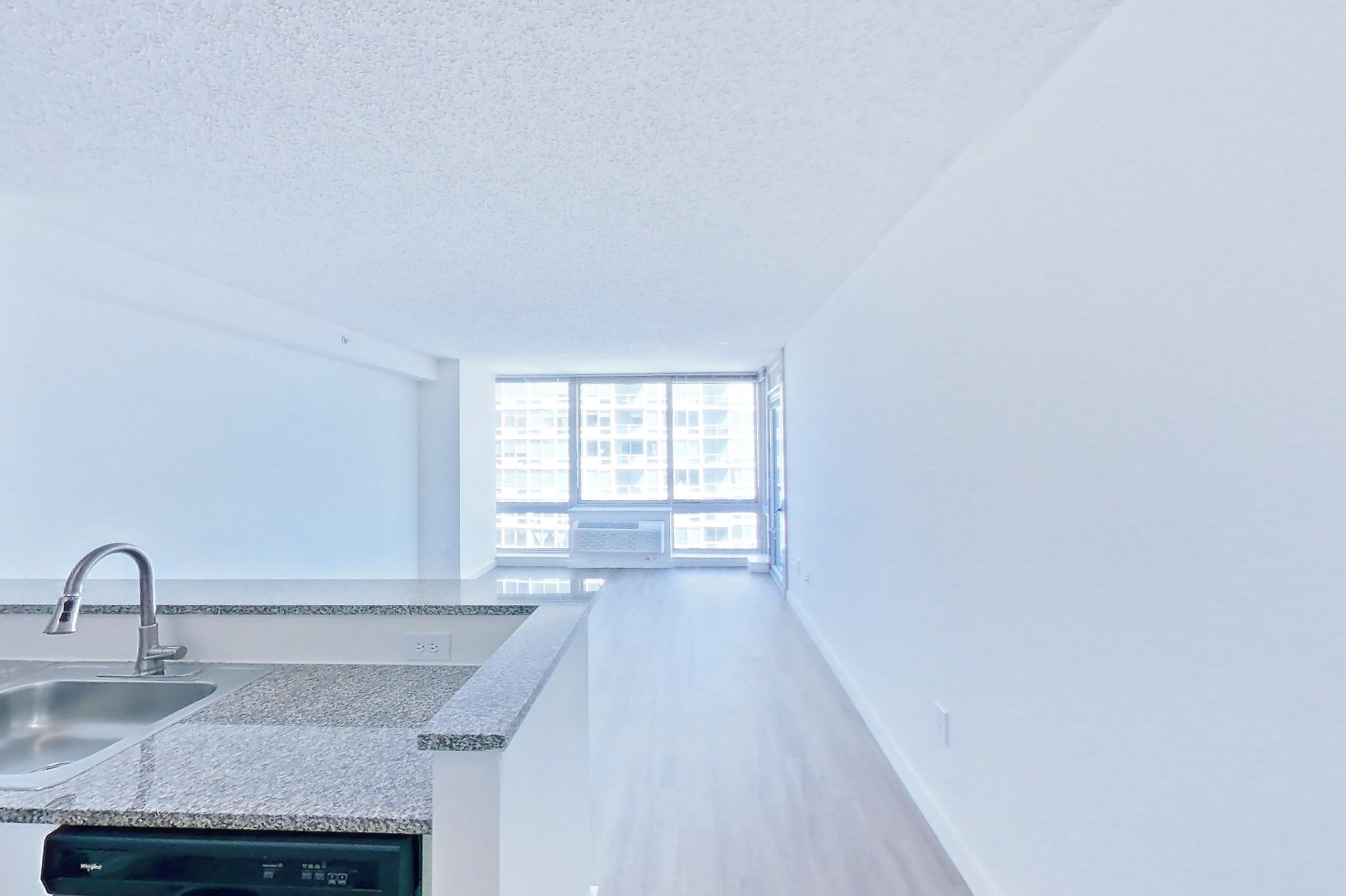 Kitchen with dark wood-finish flooring, dishwasher, electric range, light stone countertops, light wood-finish flooring, oven/range, refrigerator, and stainless steel appliances, Apartment LT-W2310 at Liberty Towers