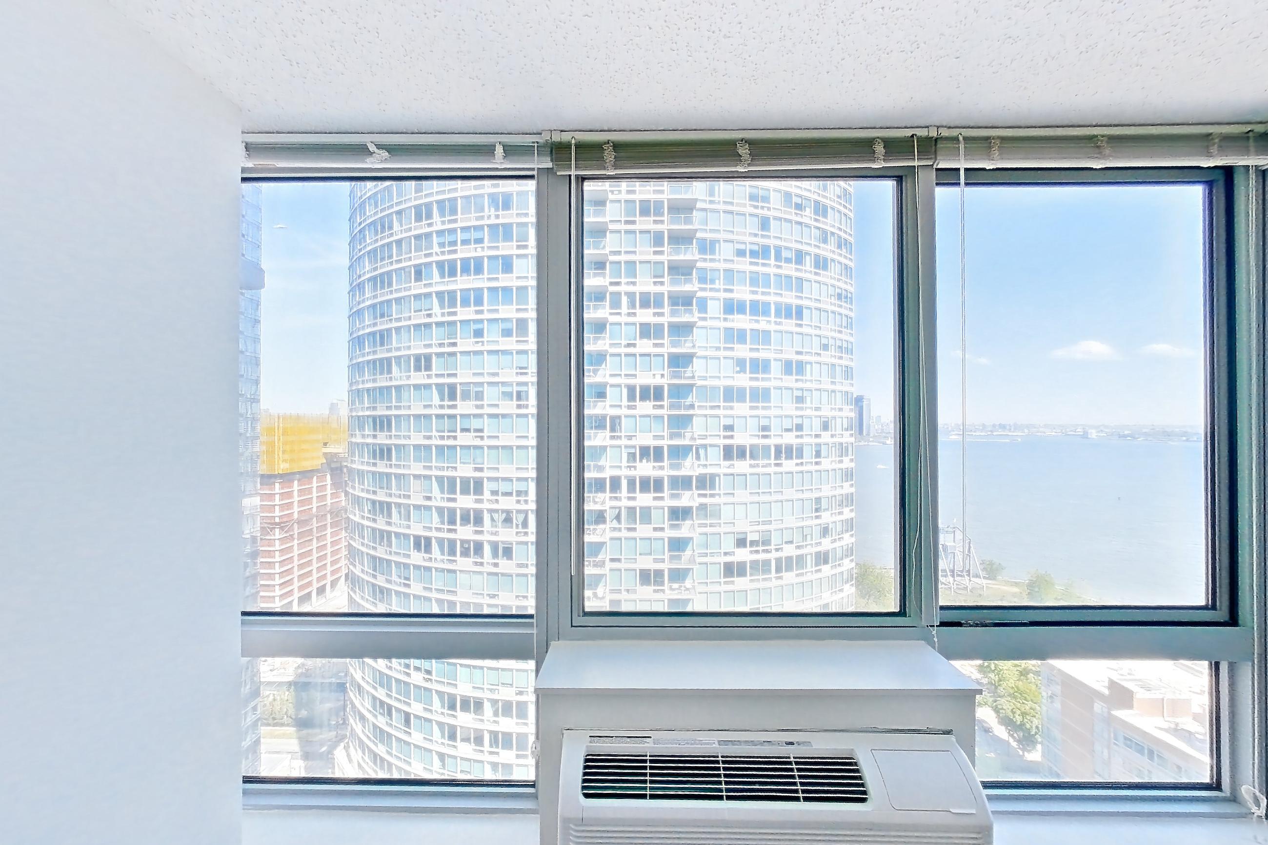 Living room with air conditioning and dark wood-finish flooring, Apartment LT-W2310 at Liberty Towers