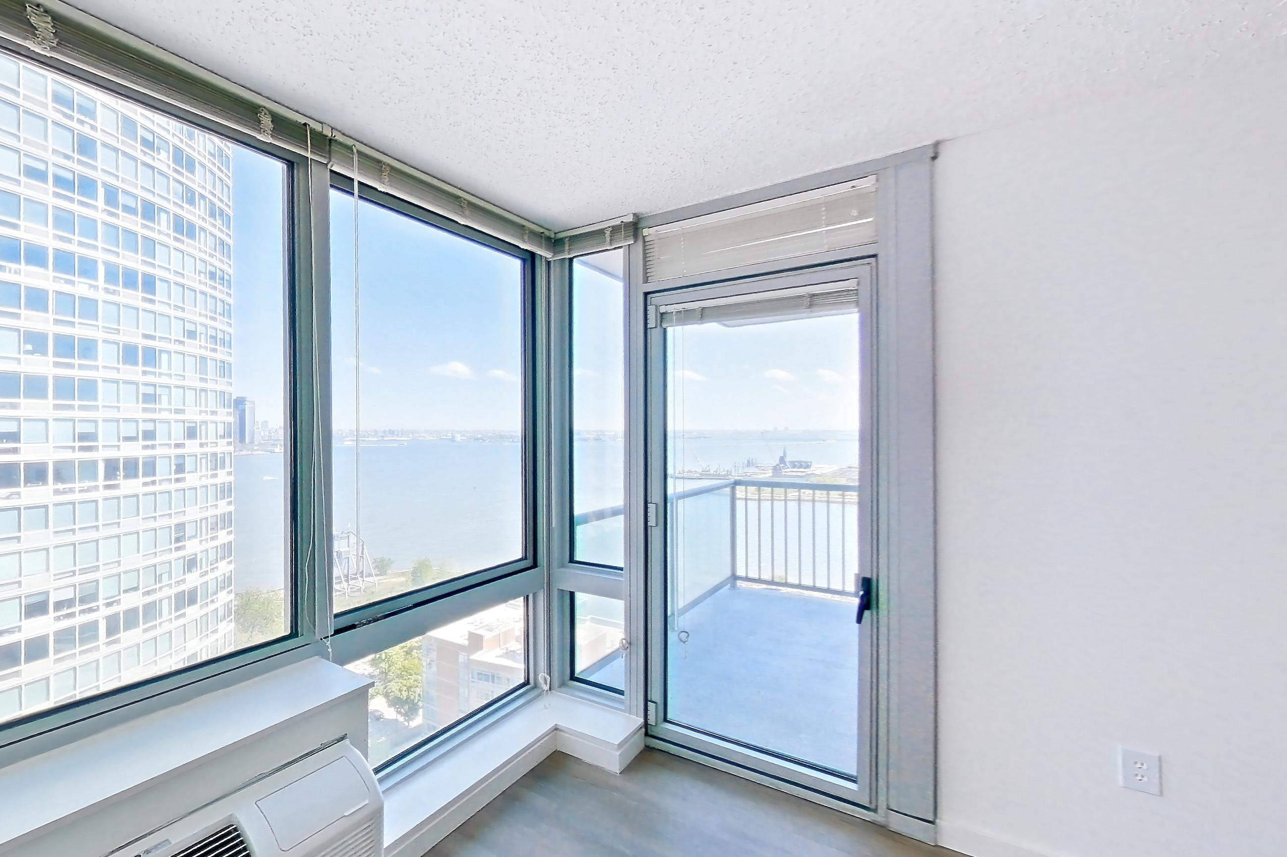 Living room with air conditioning and dark wood-finish flooring, Apartment LT-W2310 at Liberty Towers