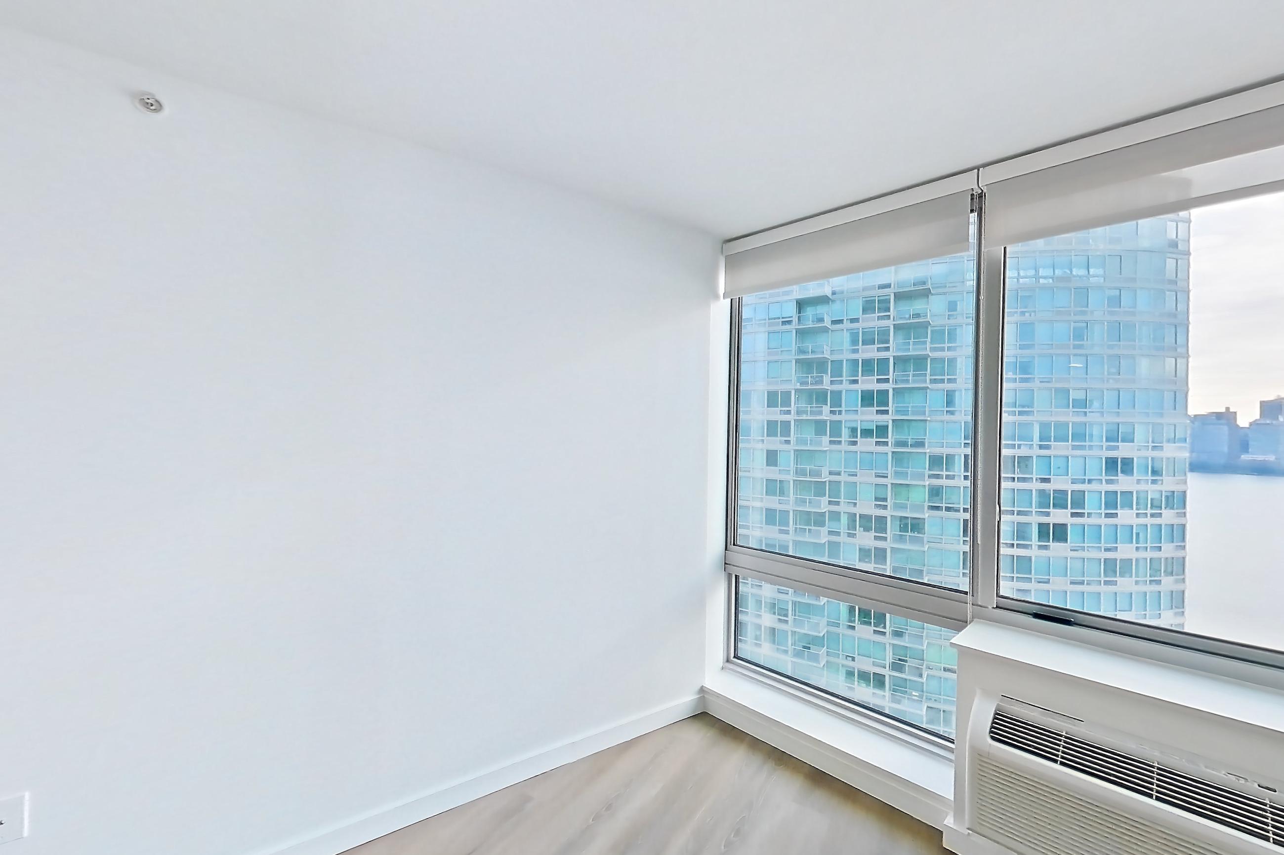 Living room with air conditioning and light wood-finish flooring, Apartment LT-W3011 at Liberty Towers