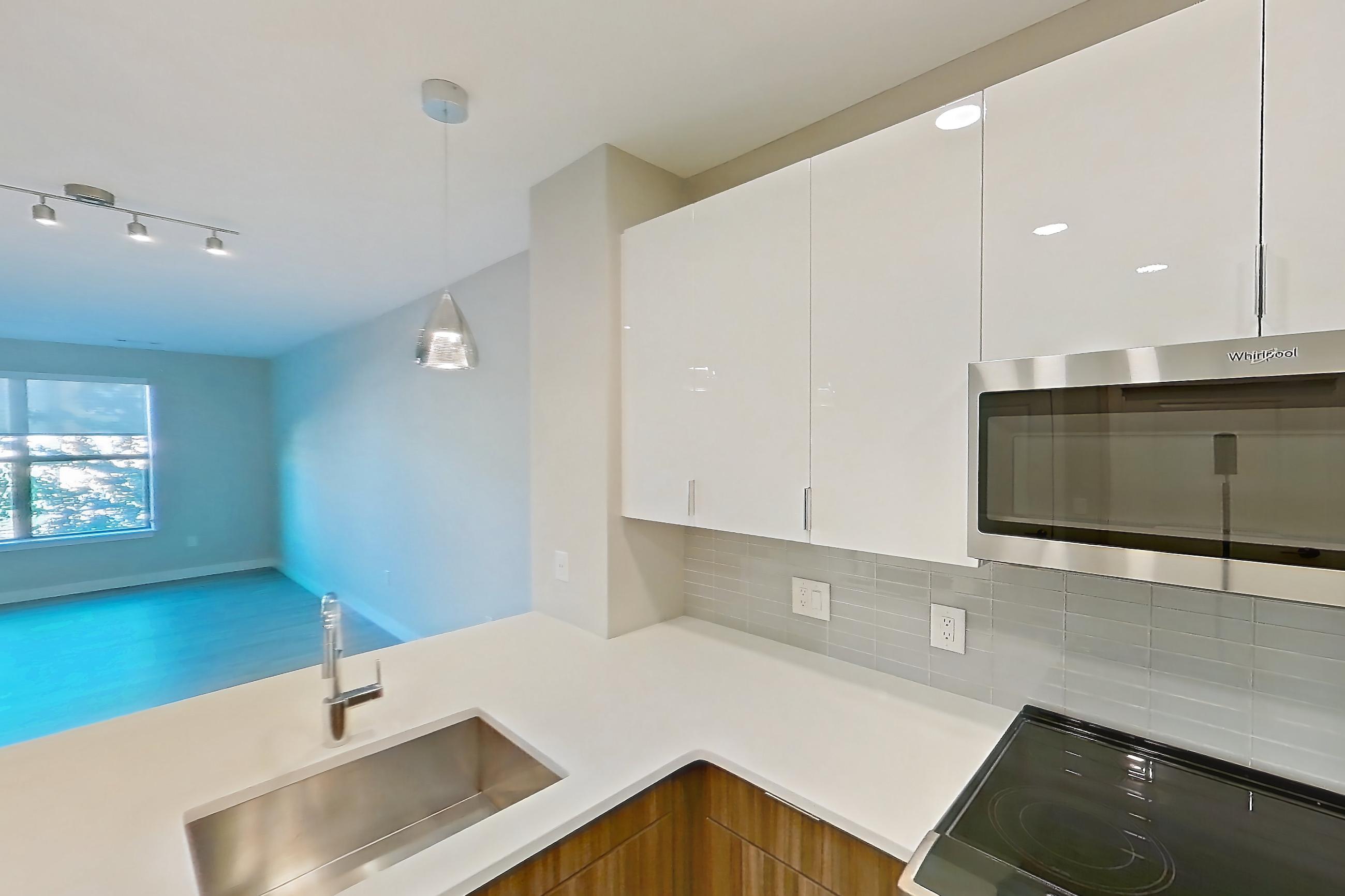 Kitchen with dishwasher, electric range, light countertops, light wood-finish flooring, and stainless steel appliances, Apartment EM-7208 at The Emery at Overlook Ridge